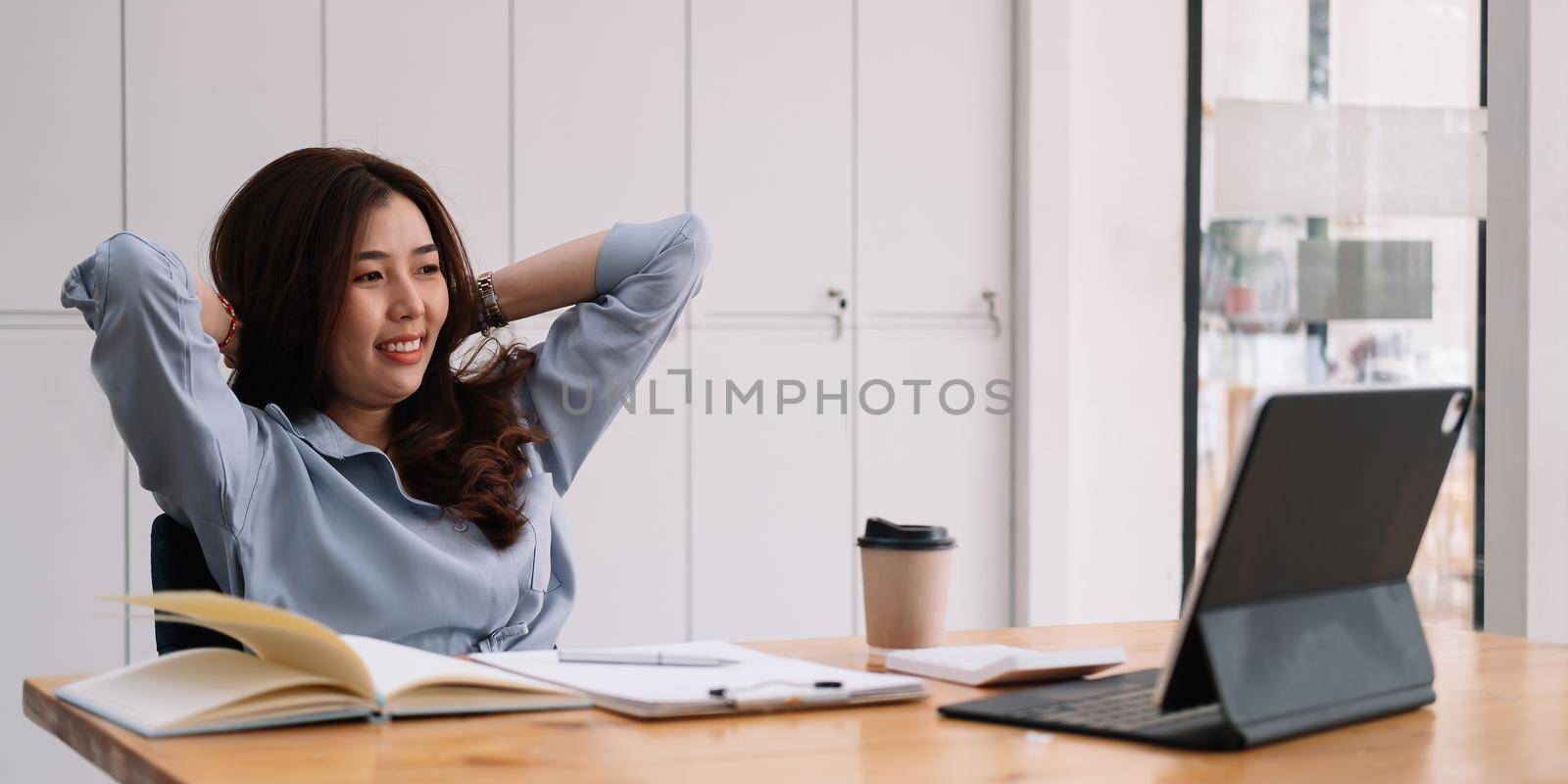 Smiling asian woman using laptop computer at office