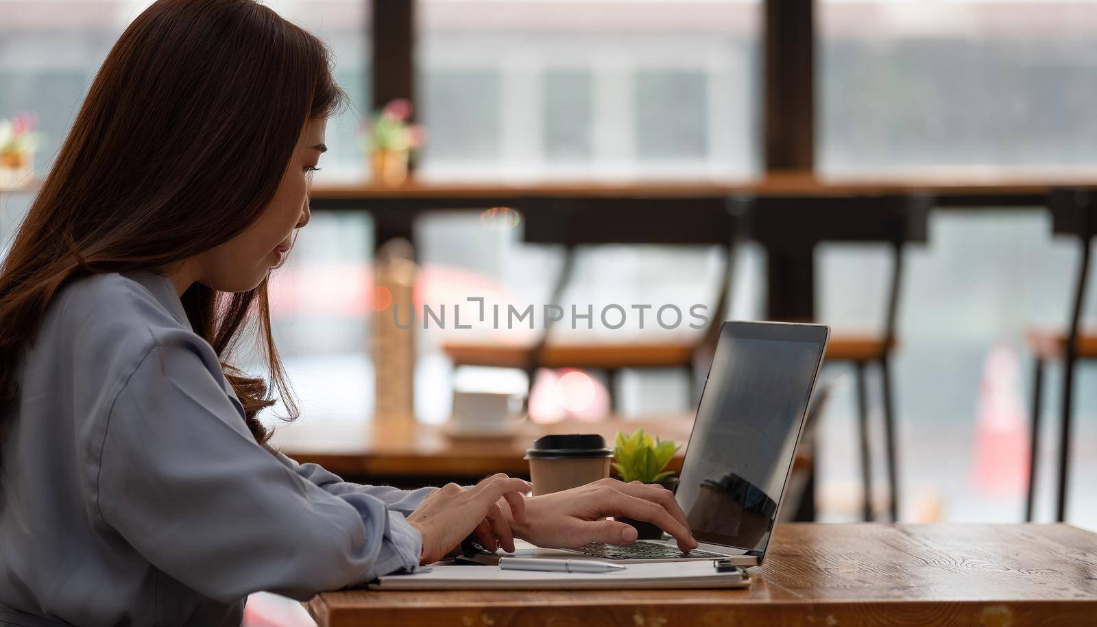 Woman have study online with teacher, happy young woman learn lecture watch webinar write notes look at laptop sit in cafe, distant education. by nateemee