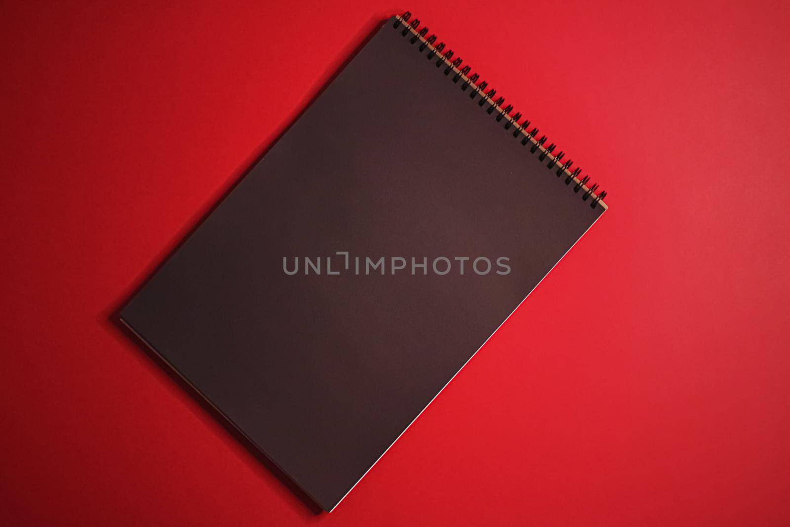 Black notebook on red background as office stationery flatlay, luxury branding flat lay and brand identity design for mockups