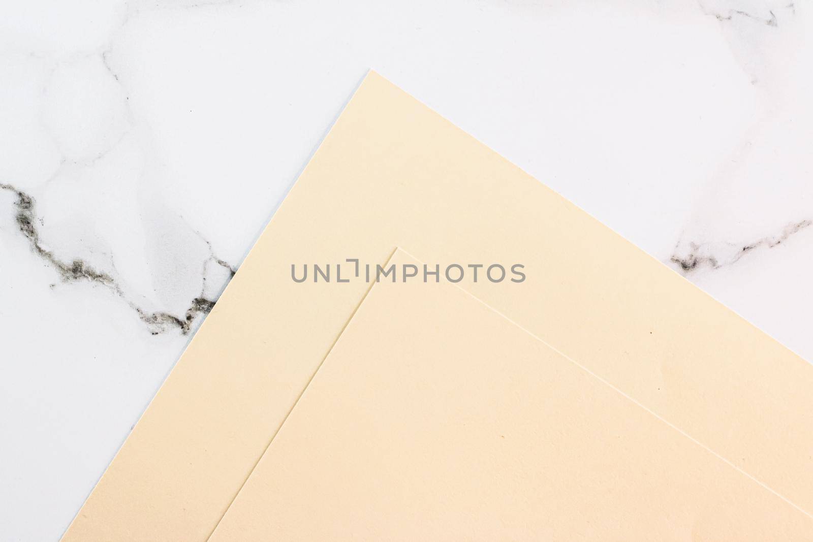 Beige A4 papers on white marble background as office stationery flatlay, luxury branding flat lay and brand identity design for mockups