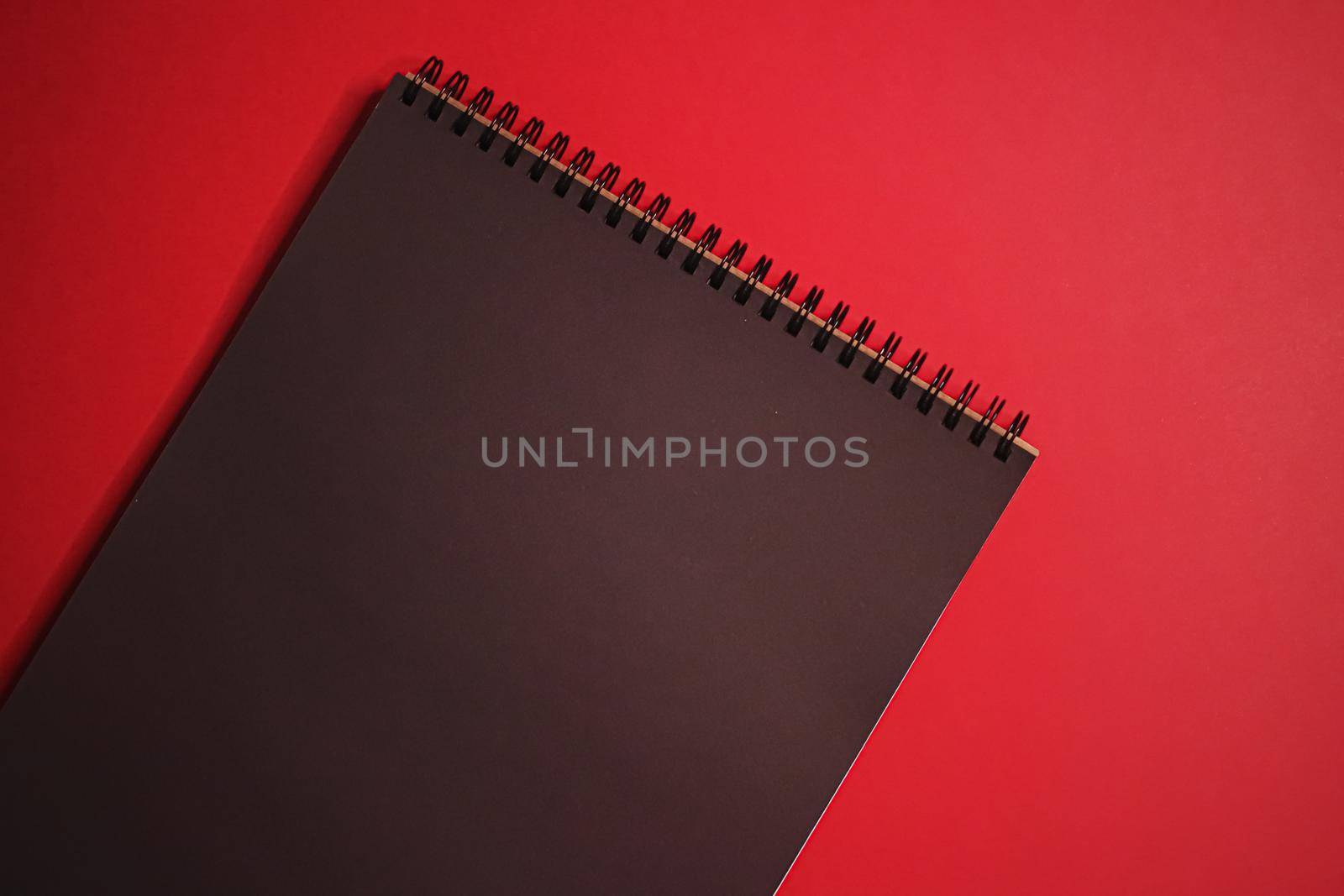 Black notebook on red background as office stationery flatlay, luxury branding flat lay and brand identity design for mockups