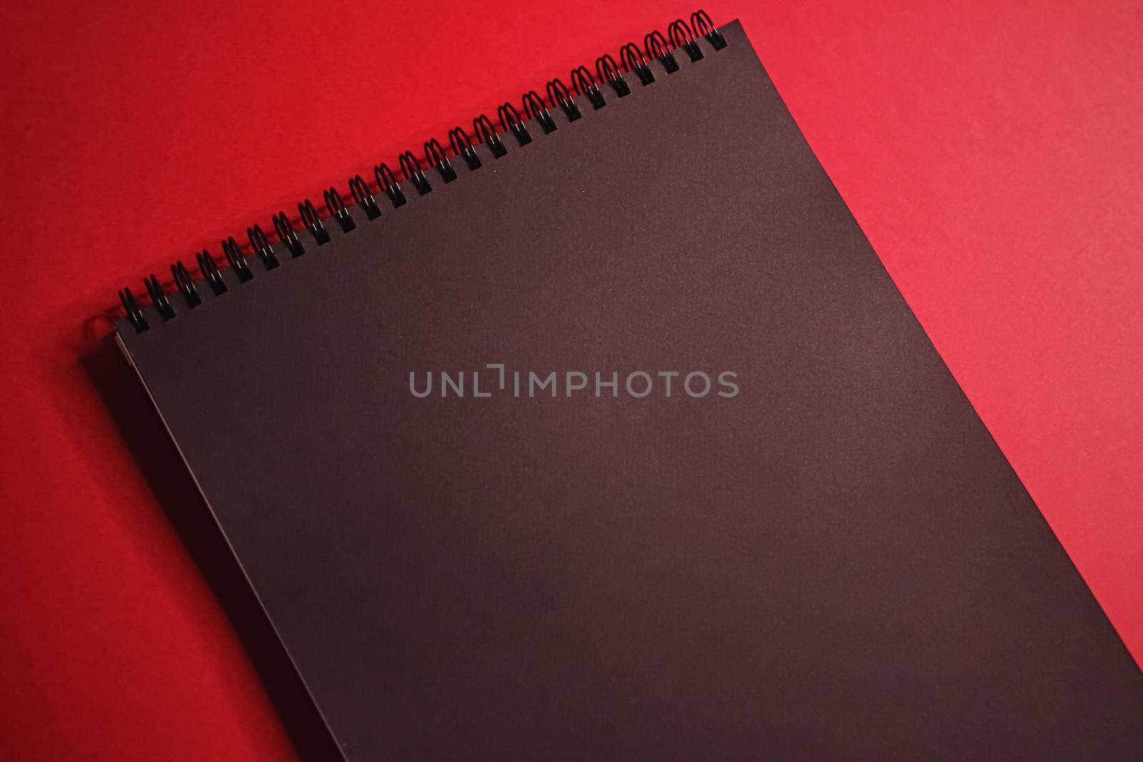 Black notebook on red background as office stationery flatlay, luxury branding flat lay and brand identity design for mockup by Anneleven