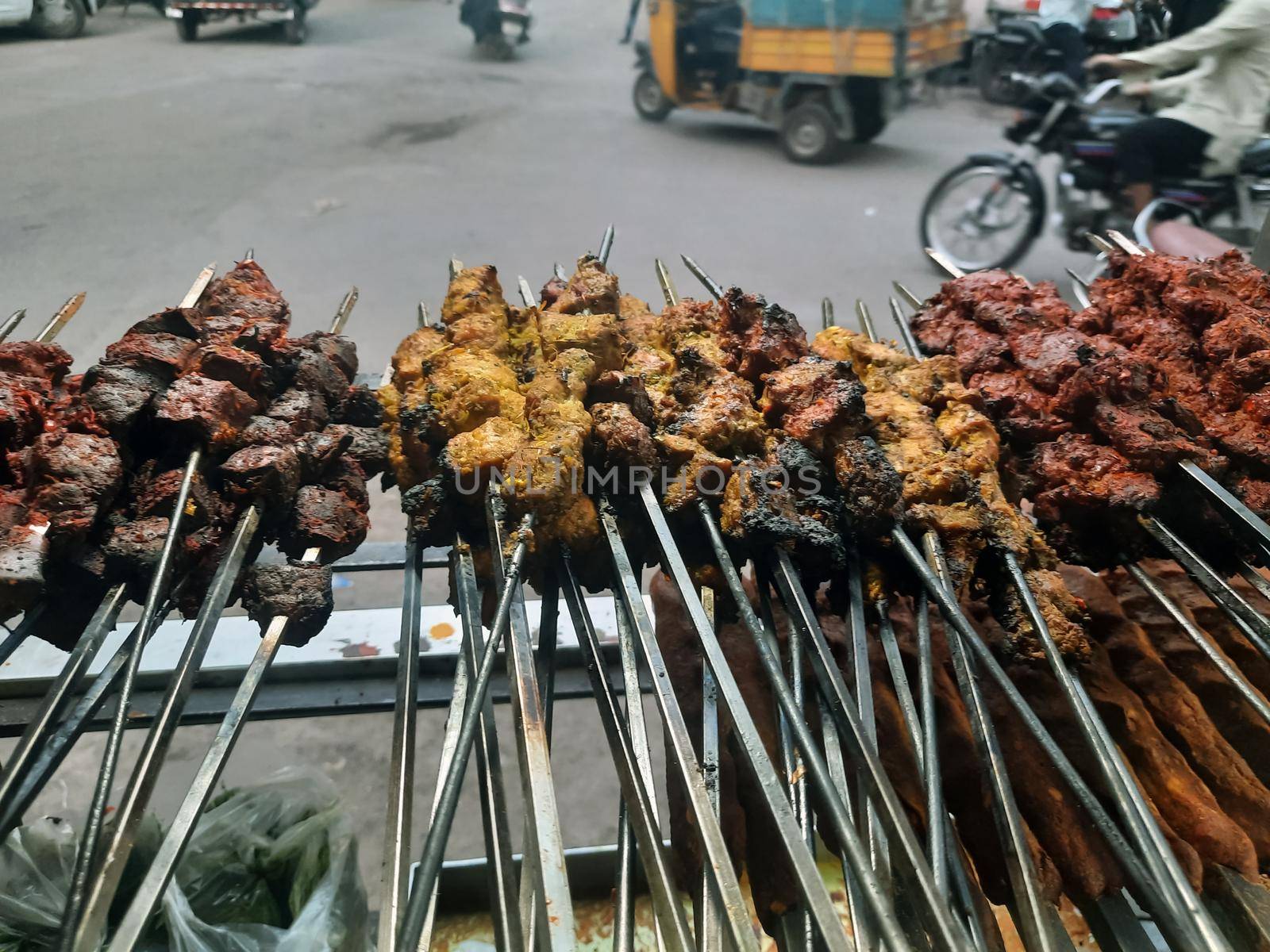 Spicy chicken seekh kababs are being grilled with charcoal in barbeque with metal skewers,at evening for sale as street food in Old Delhi market. It is famous for spicy non vegetarian street foods.