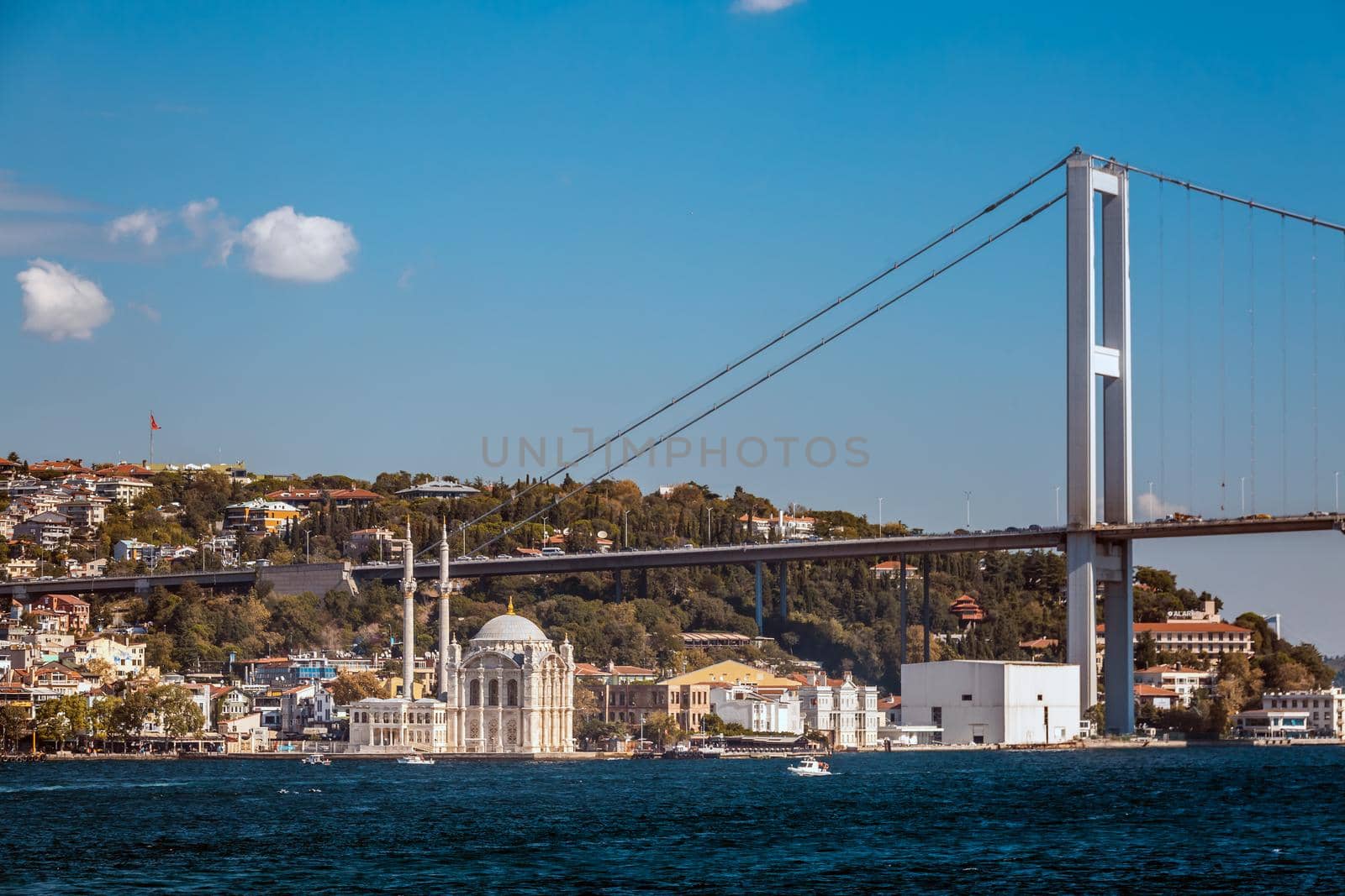 Ortakoy Camii mosque with two minarets and new bridge at the background in Istanbul, Turkey.