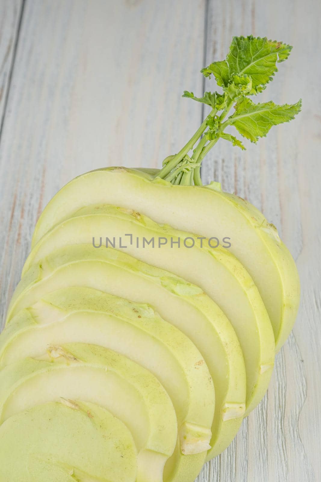 Fresh healthy kohlrabi sliced on wooden background.