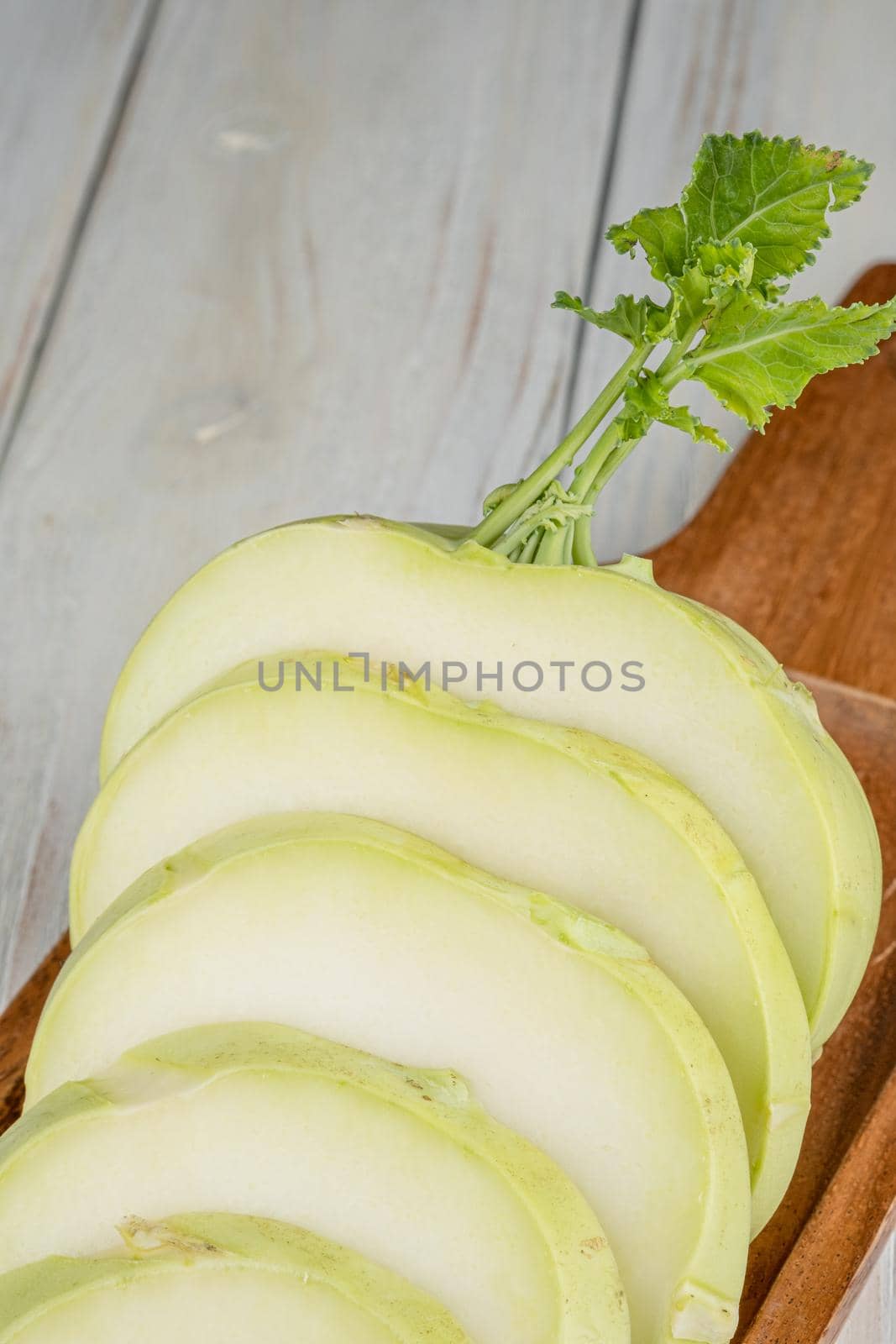 Fresh healthy kohlrabi sliced on wooden background.