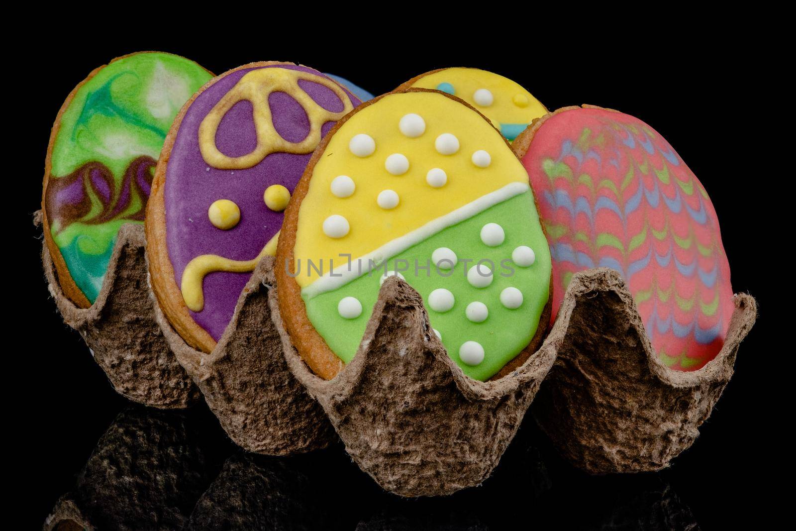 Easter decorated baked eggs, cookies on a black background.