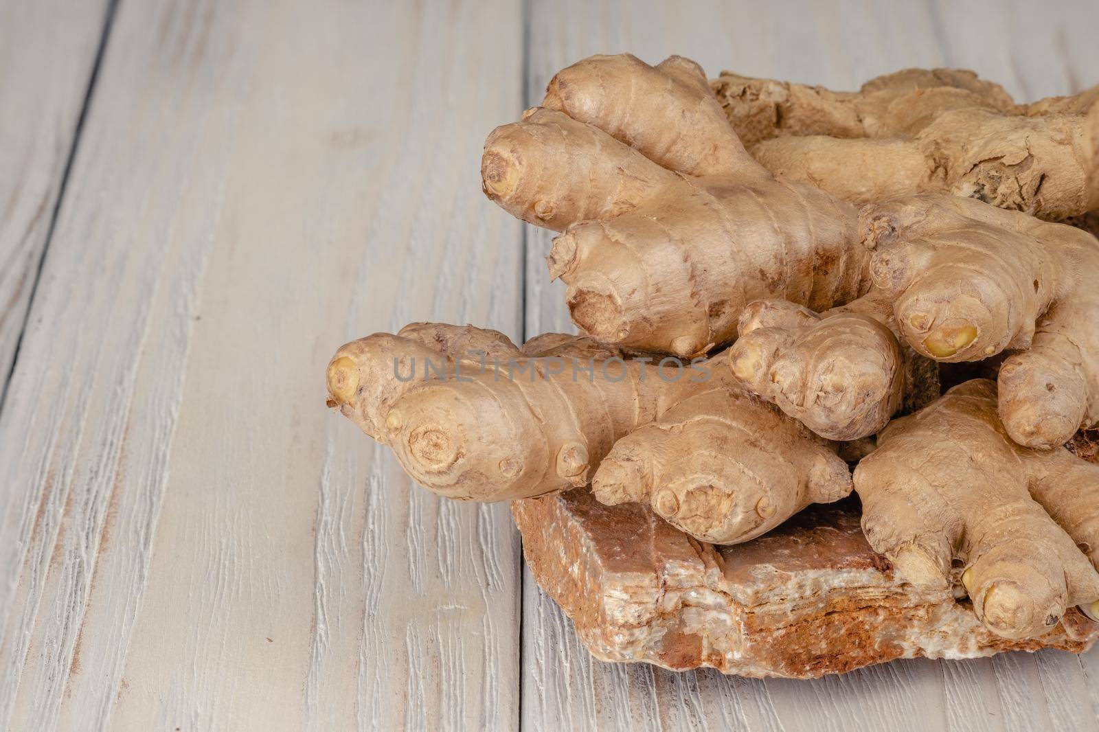 Fresh, light, healthy ginger on white wooden background.