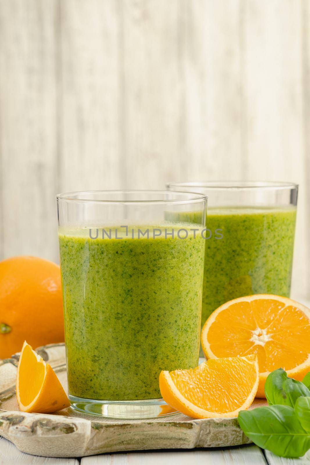 Healthy green smoothie with spinach, mango, orange,lime, apple,citrone in glass jars.