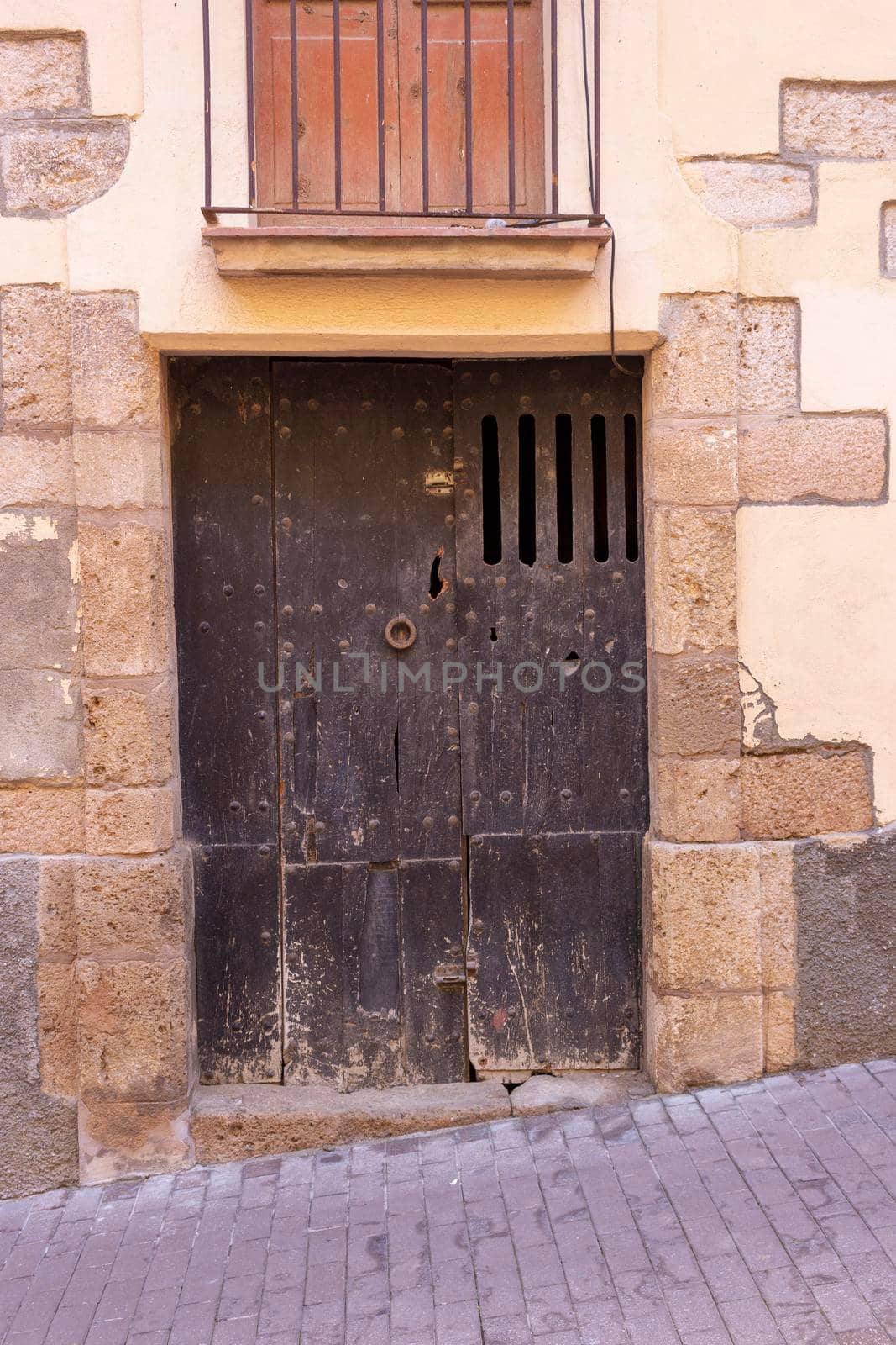Old wooden door with stone arch, in Girona, Catalonia, Spain