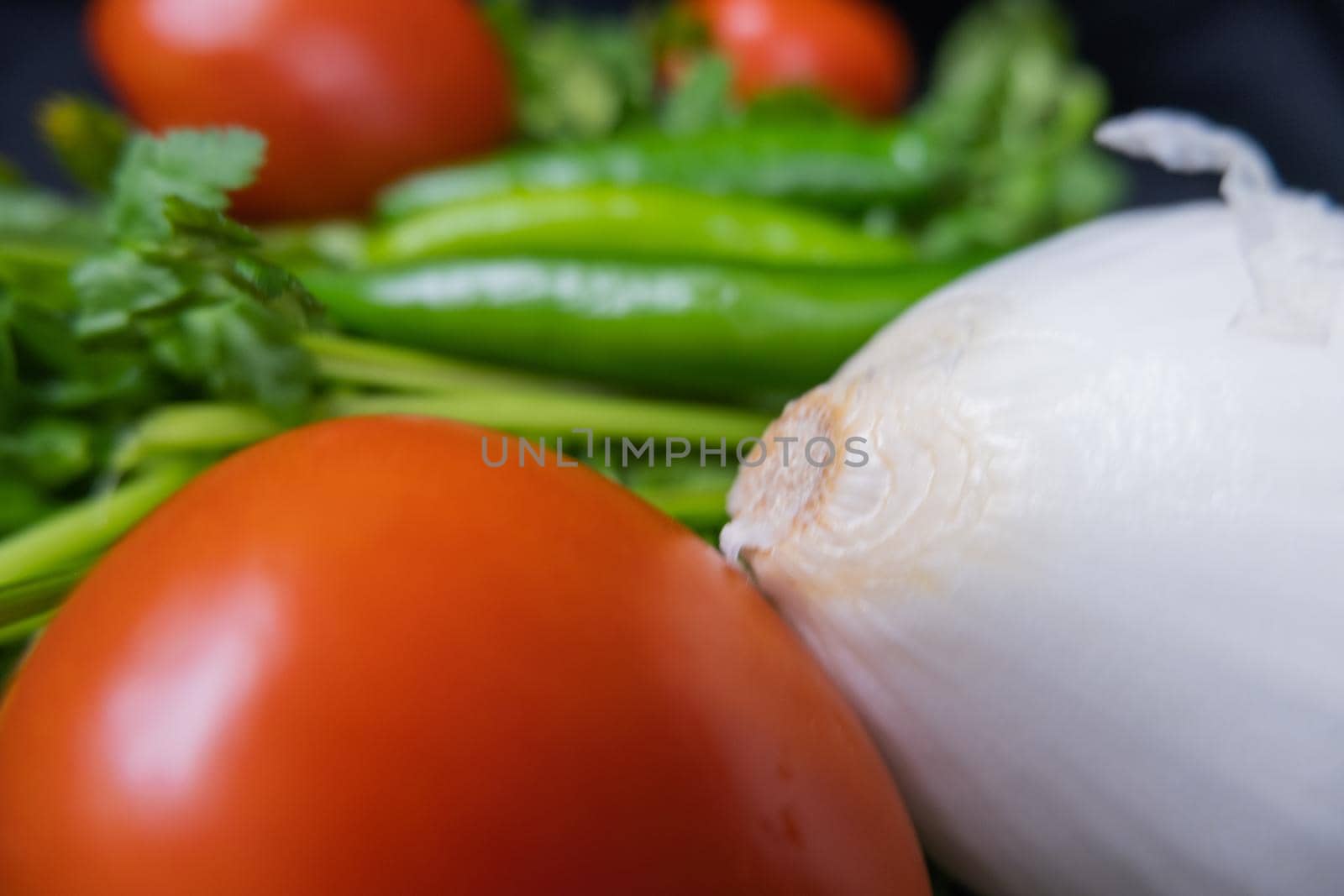 Chili peppers, onion, and a tomato above coriander by Kanelbulle