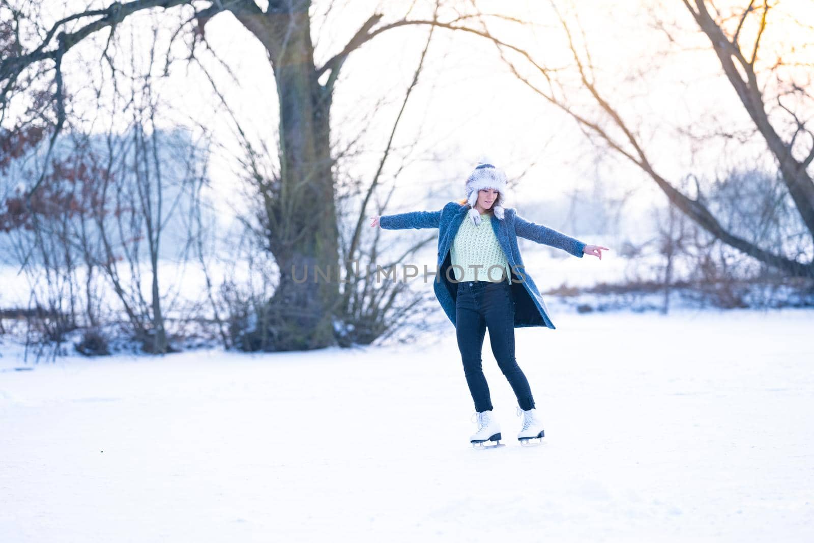 ice skating on the ice of a frozen lake young attractive woman by Edophoto