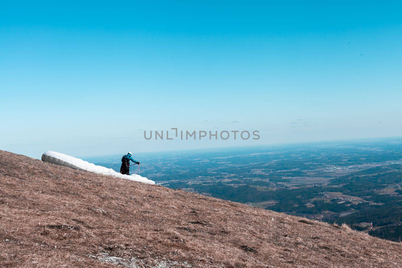 sports paragliding on a parachute over the countryside.