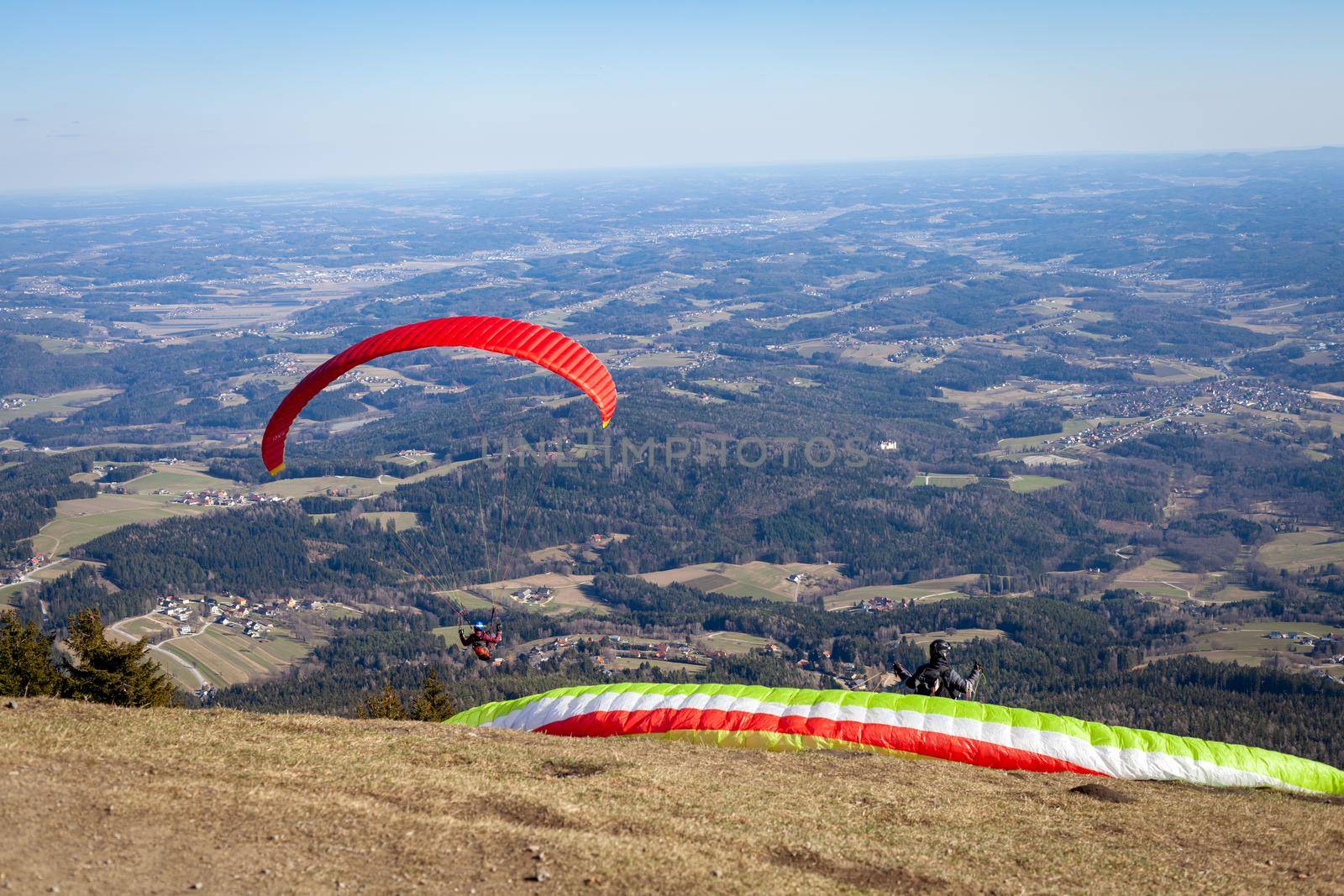 sports paragliding on a parachute over the countryside.