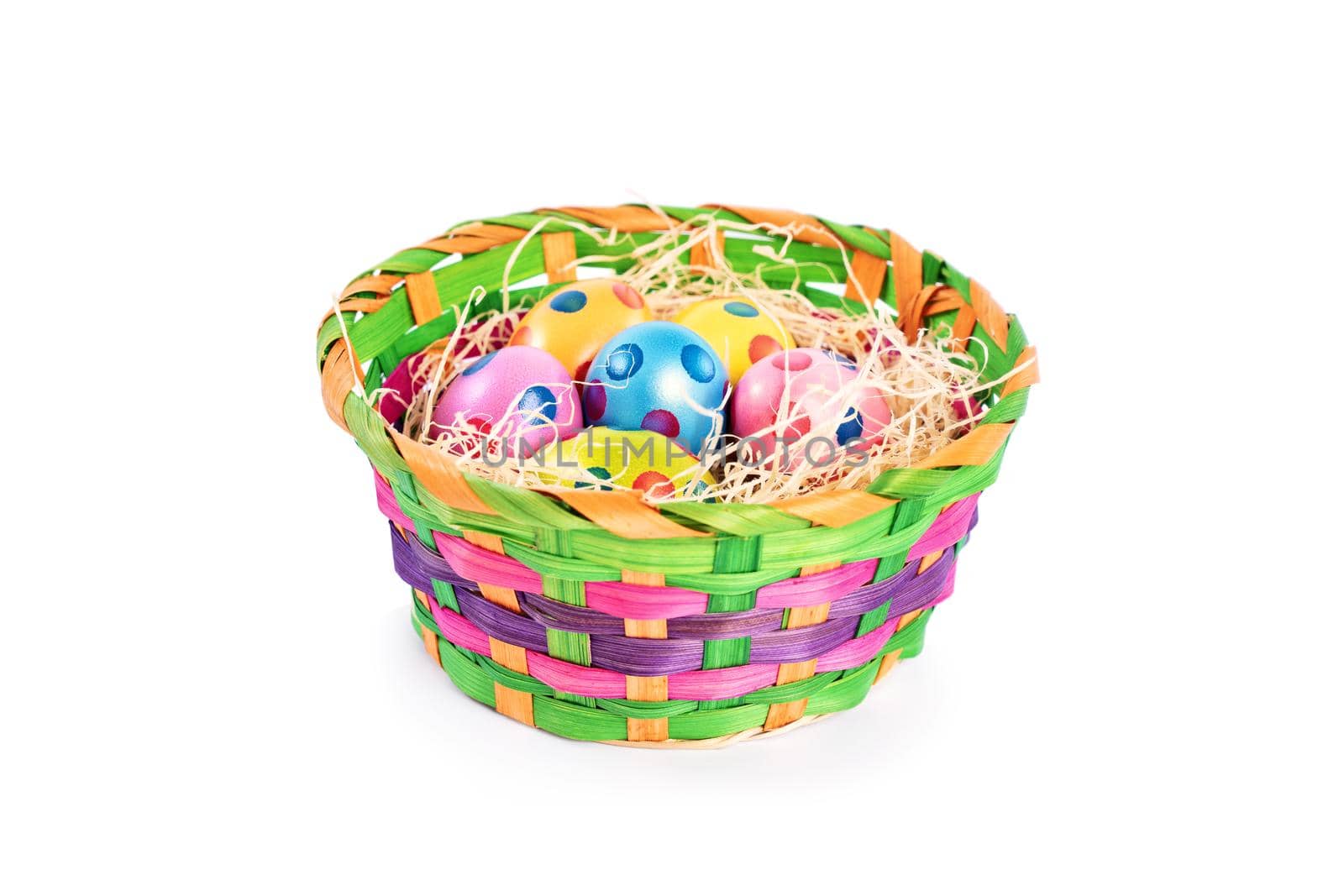Colourful Easter eggs with polka dots in a basket, isolated on white background. Easter celebration concept.