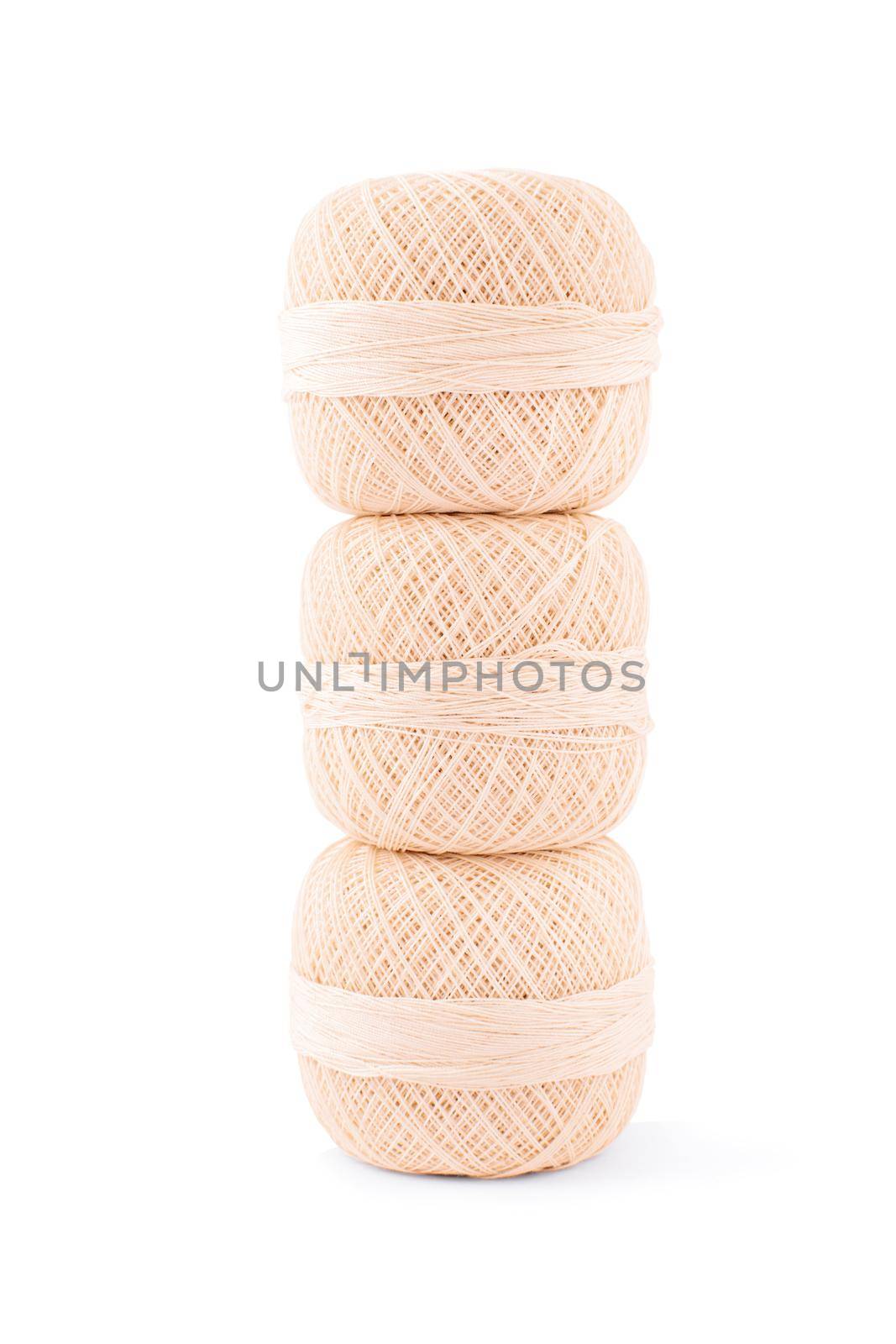 Close up shot of three spools of embroidery thread on top of each other, isolated on white background.