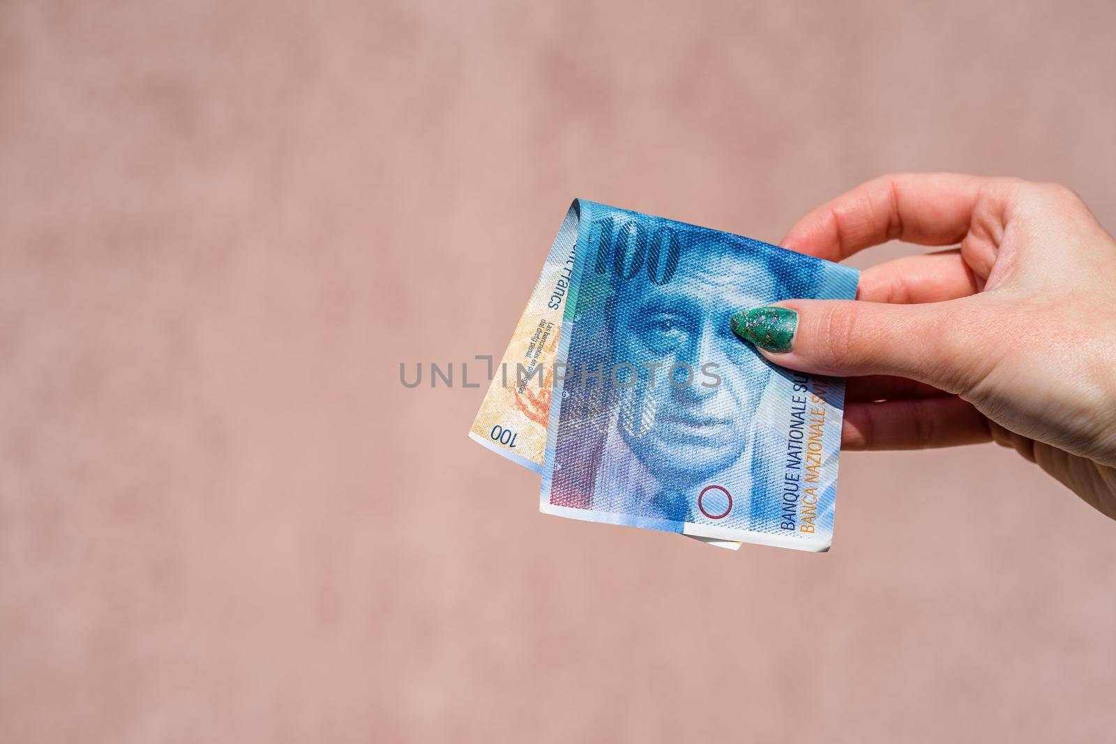 Hand holding showing euro money and giving or receiving money like tips, salary. 100 swiss franc banknotes CHF currency isolated. Concept of rich business people, saving or spending money.