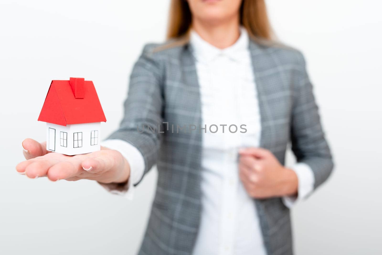 Holding Your new house in hands against spring green background. Real estate and healthy lifestyle concept.