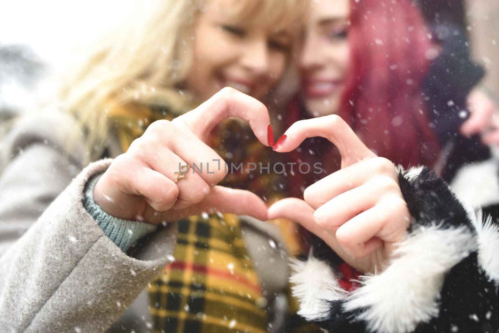 Lesbian couple making heart with hands, open relationship in same-sex love. best Girlfriends. Friendship concept. by Nickstock
