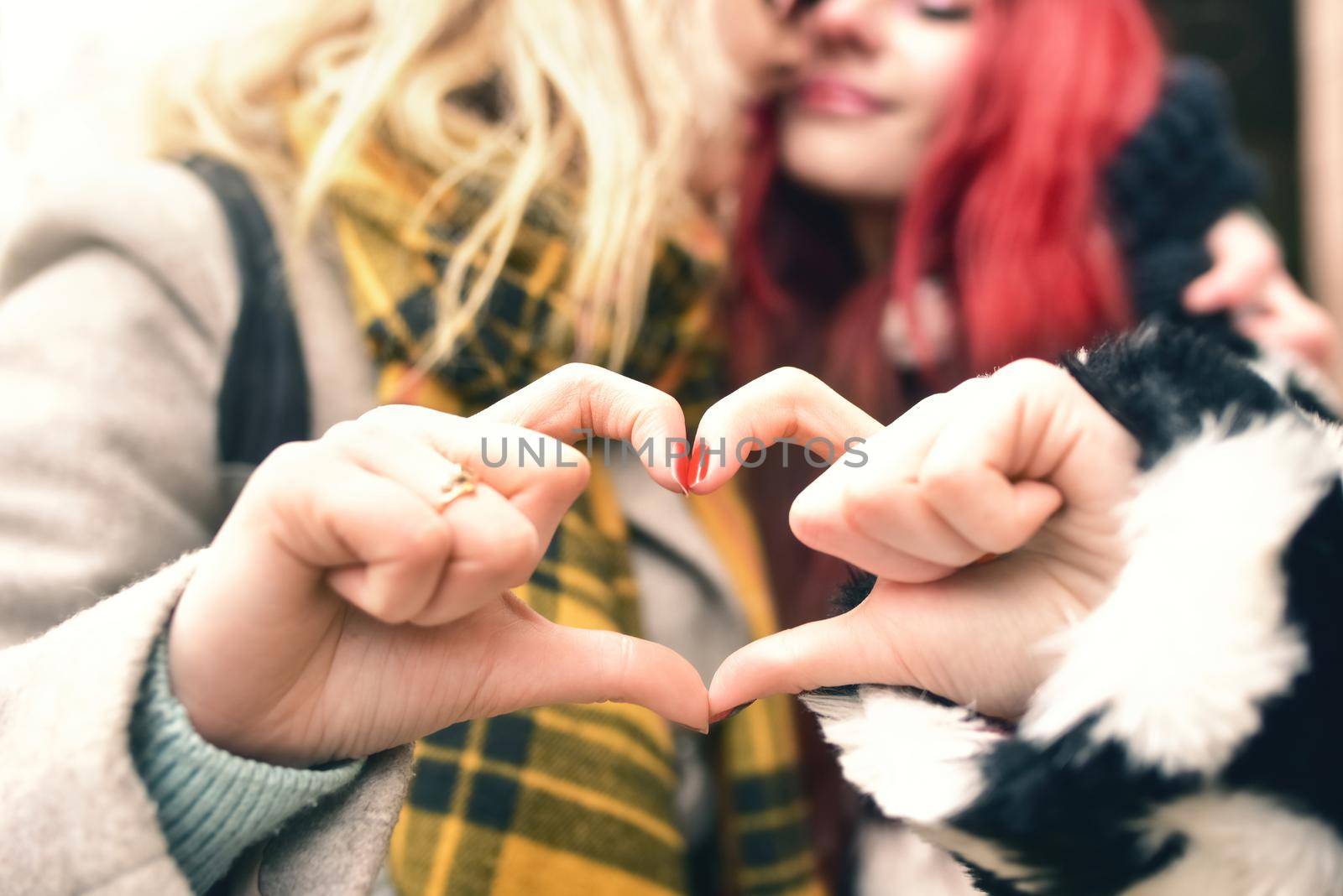 Lesbian couple making heart with hands, open relationship in love. love concept. friendship concept