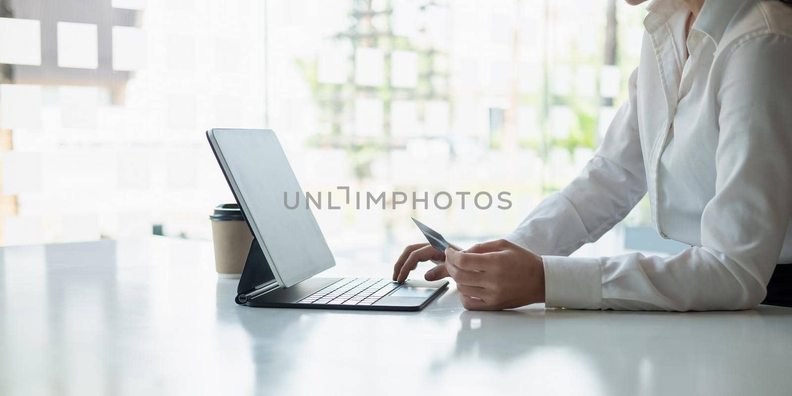 girl makes a purchase on the Internet on the smart tablet with credit card - online shopping concept