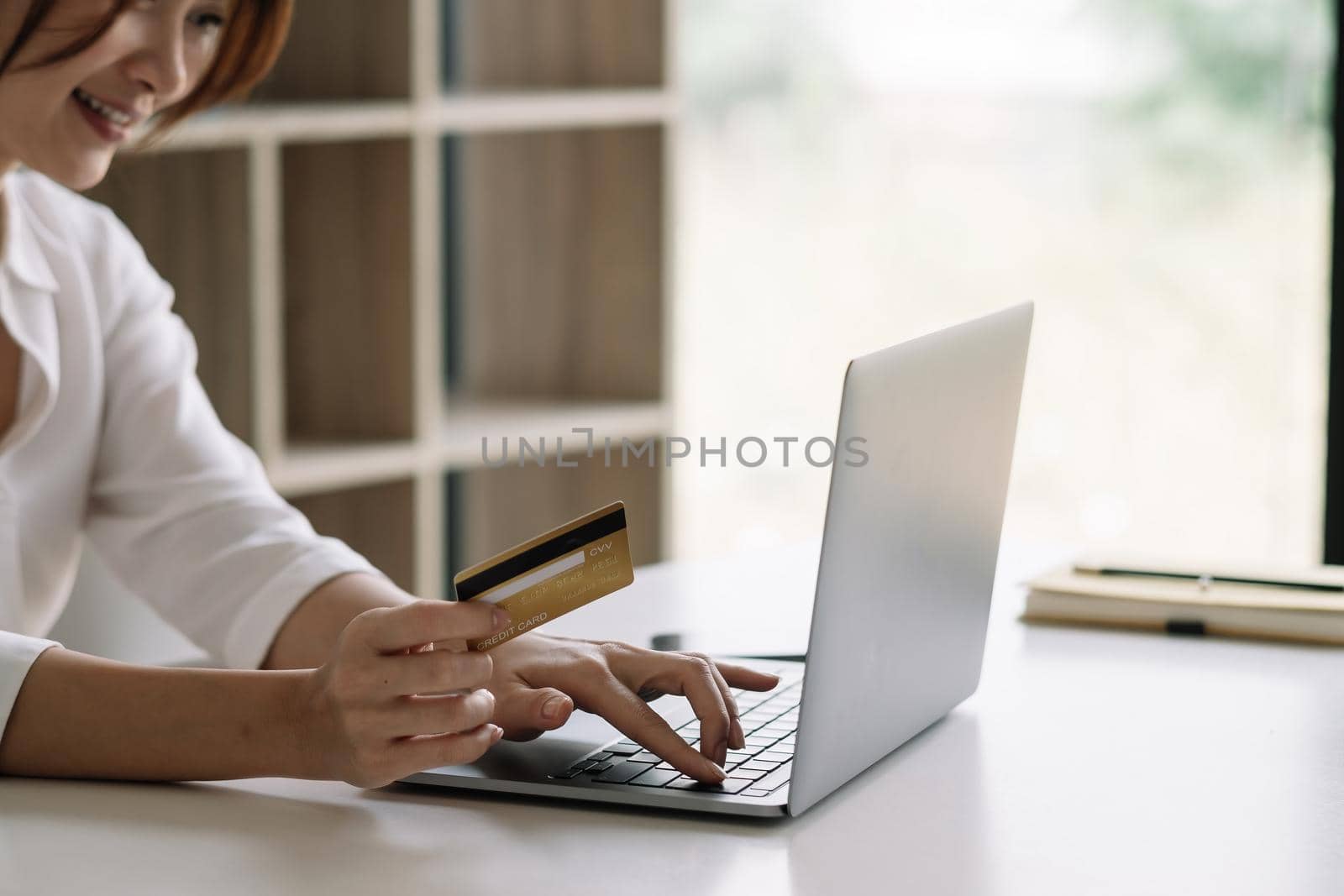Close up woman using laptop computer and credit card for shopping online at home