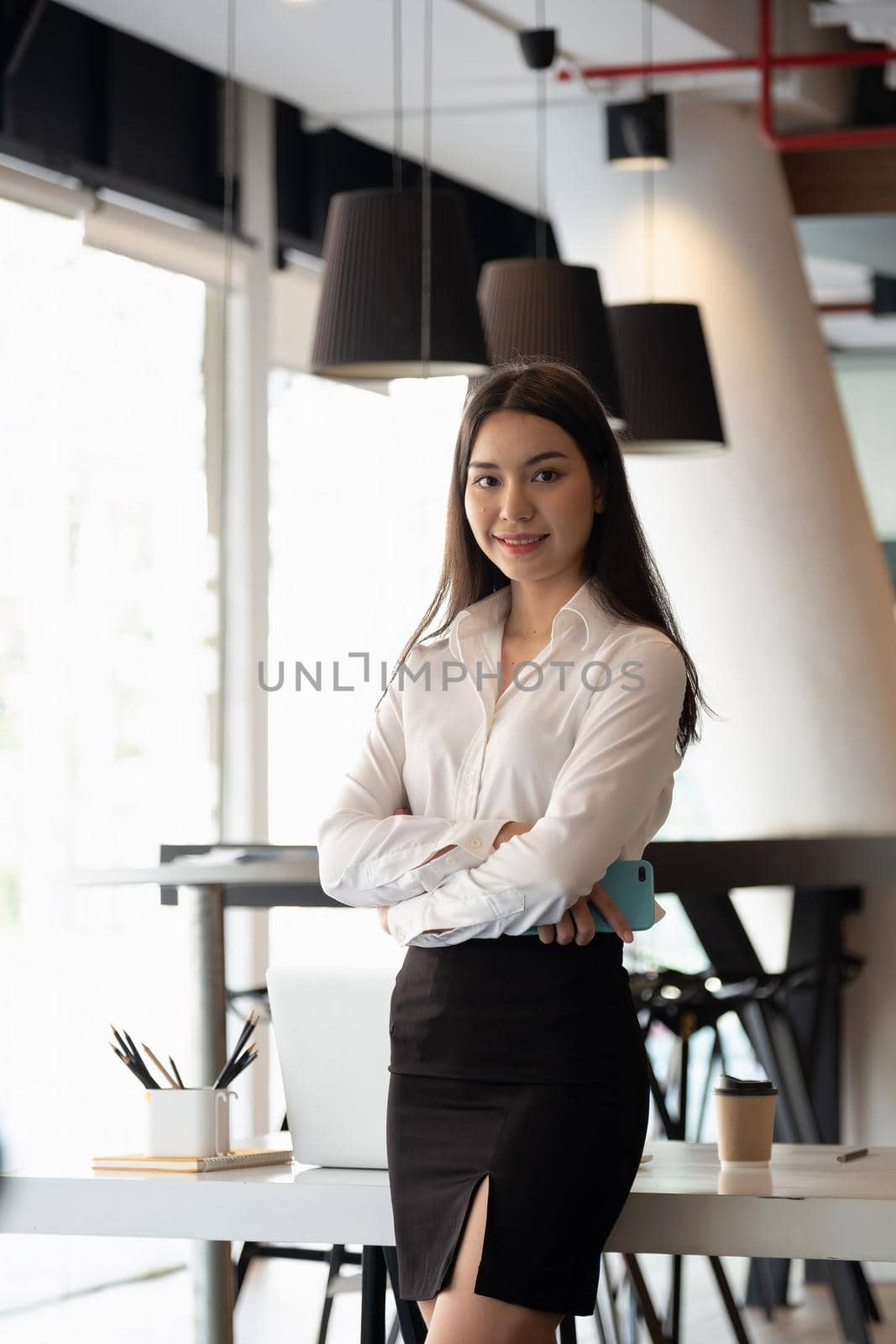 Portrait of smiling young asian business woman looking at the camera at office