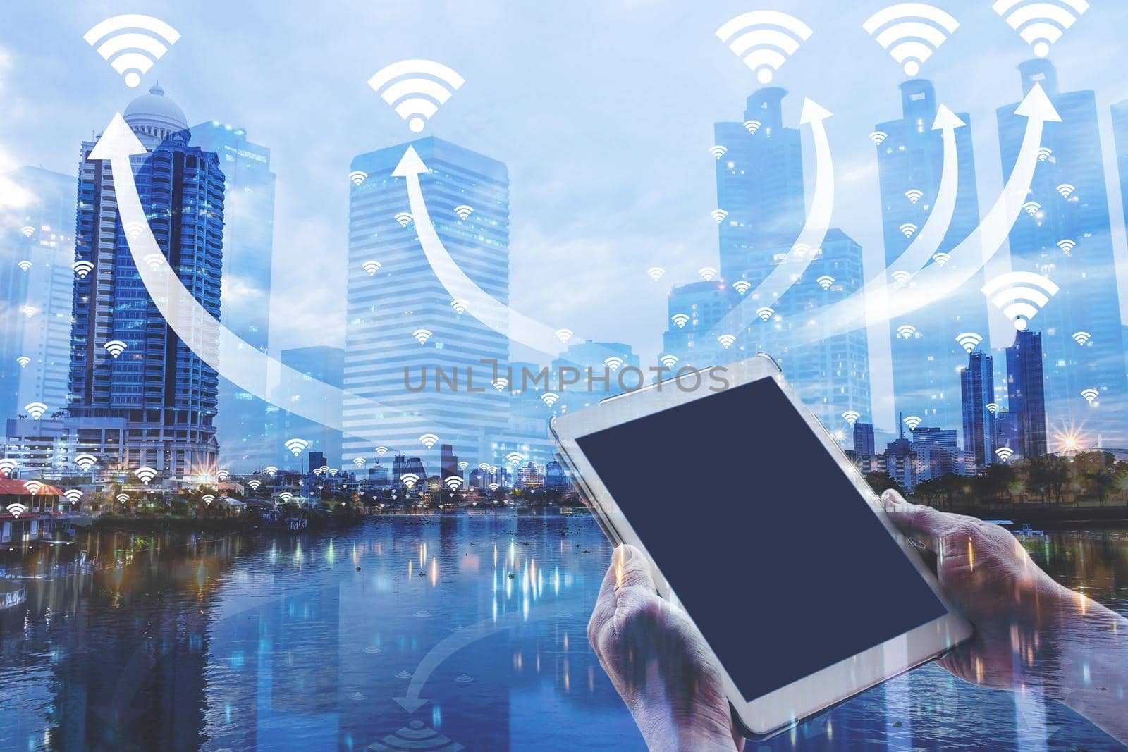 Hand holding digital tablet on the network and hotspot wireless communication network, abstract technology wifi in city night and building office center blue style