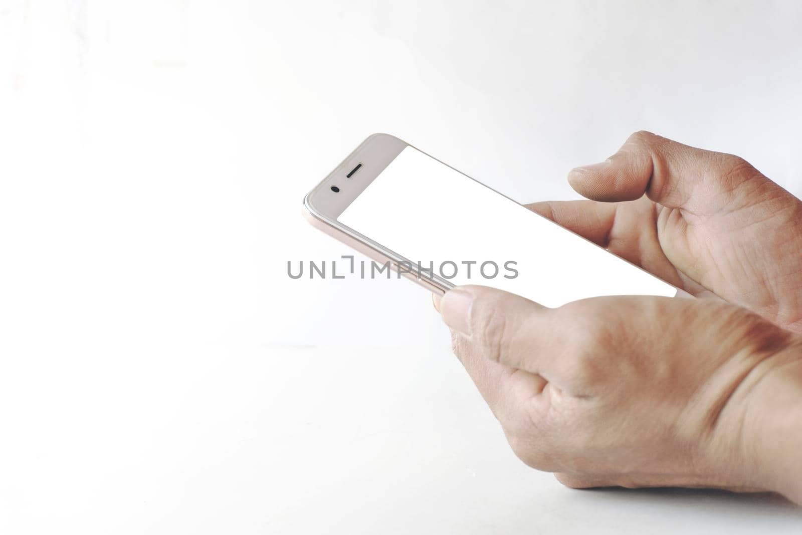 Mockup of a blank white screen cell phone. Man hand holds smartphone using mobile for message chat. White background empty space for advertising business  by yodsawai