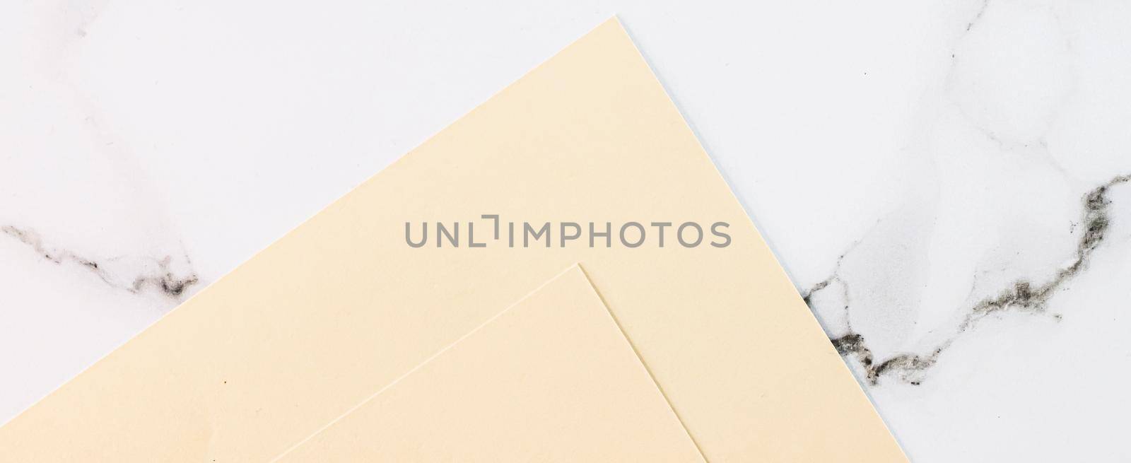 Beige A4 papers on white marble background as office stationery flatlay, luxury branding flat lay and brand identity design for mockups