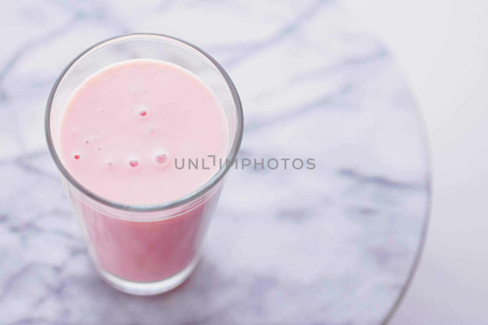 Strawberry milk on marble background as sweet drink, food service and meal delivery concept