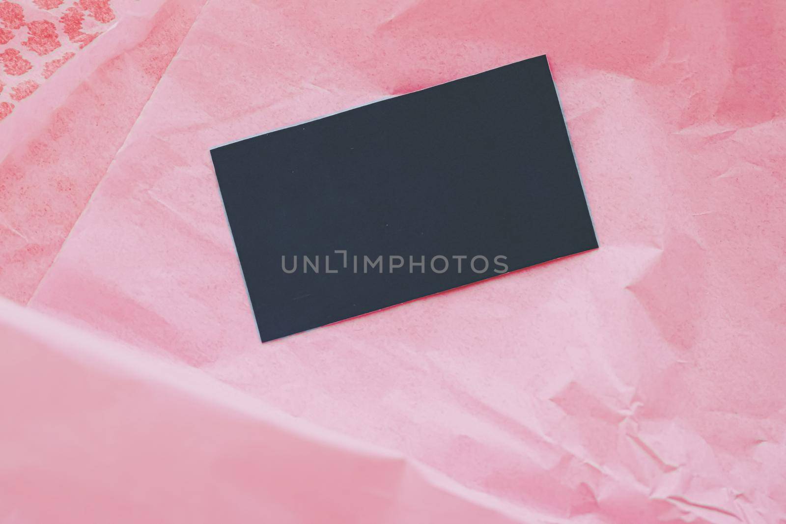 Black business card flatlay on pink tissue paper background, luxury branding flat lay and brand identity design for mockups