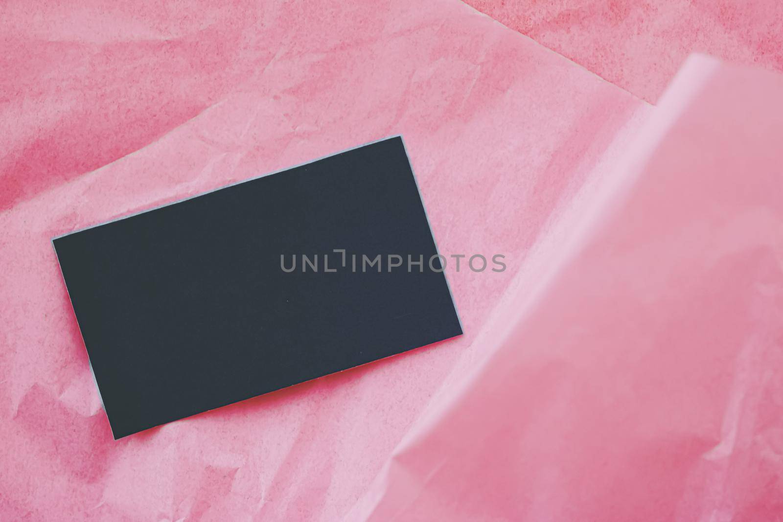 Black business card flatlay on pink tissue paper background, luxury branding flat lay and brand identity design for mockups