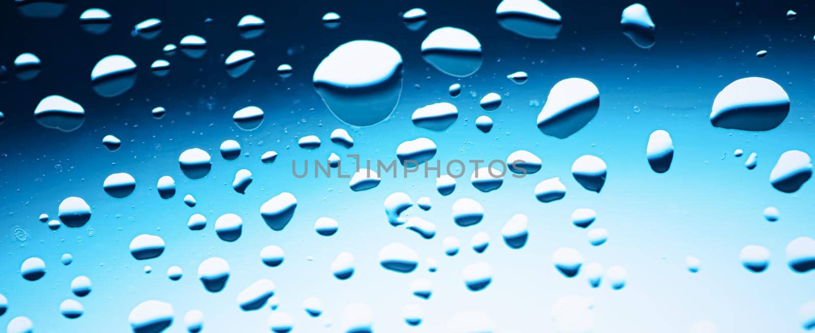 Liquid water drops on glass surface, abstract backdrop and science background concept