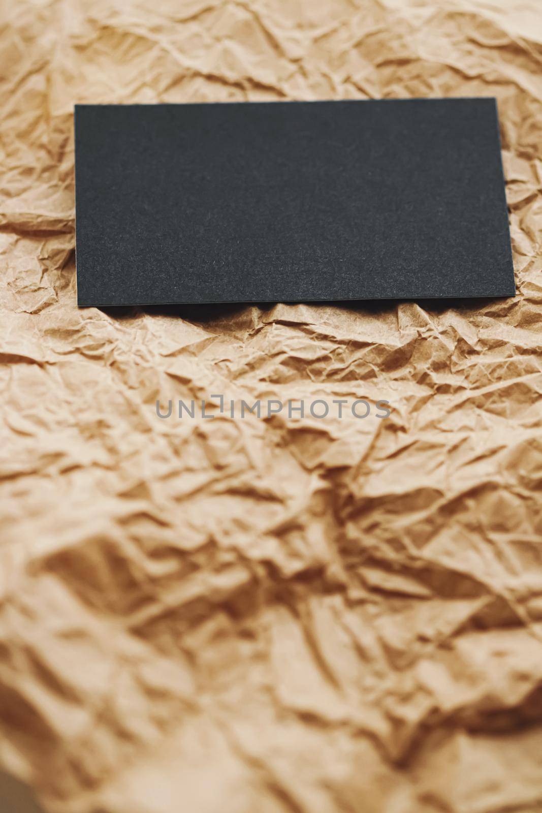 Black business card flatlay on brown parchment paper background, luxury branding flat lay and brand identity design for mockups