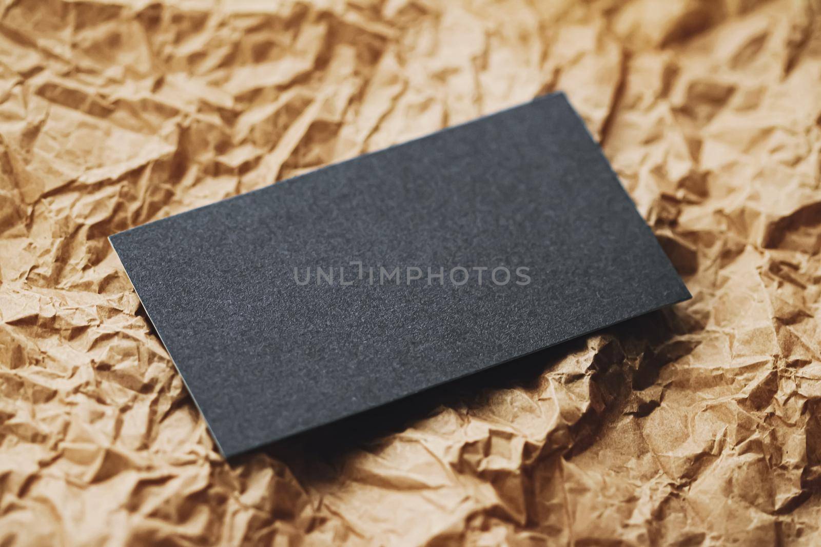 Black business card flatlay on brown parchment paper background, luxury branding flat lay and brand identity design for mockups