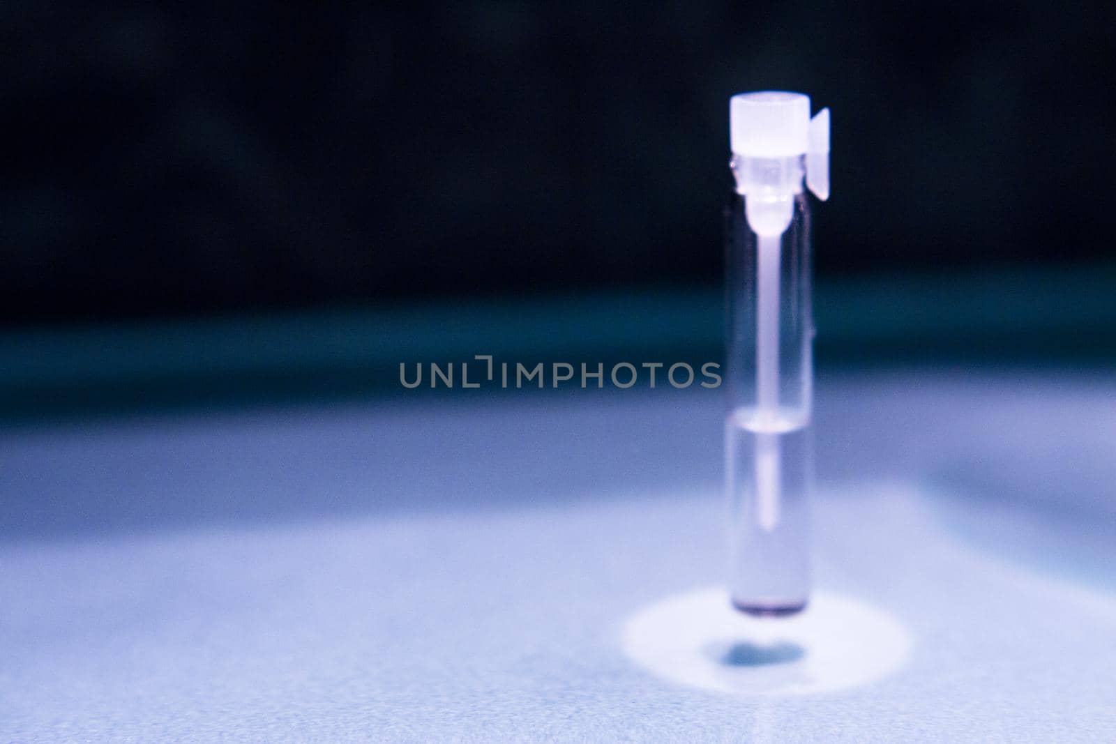 Glass bottle with perfume sample. No people. Copy space