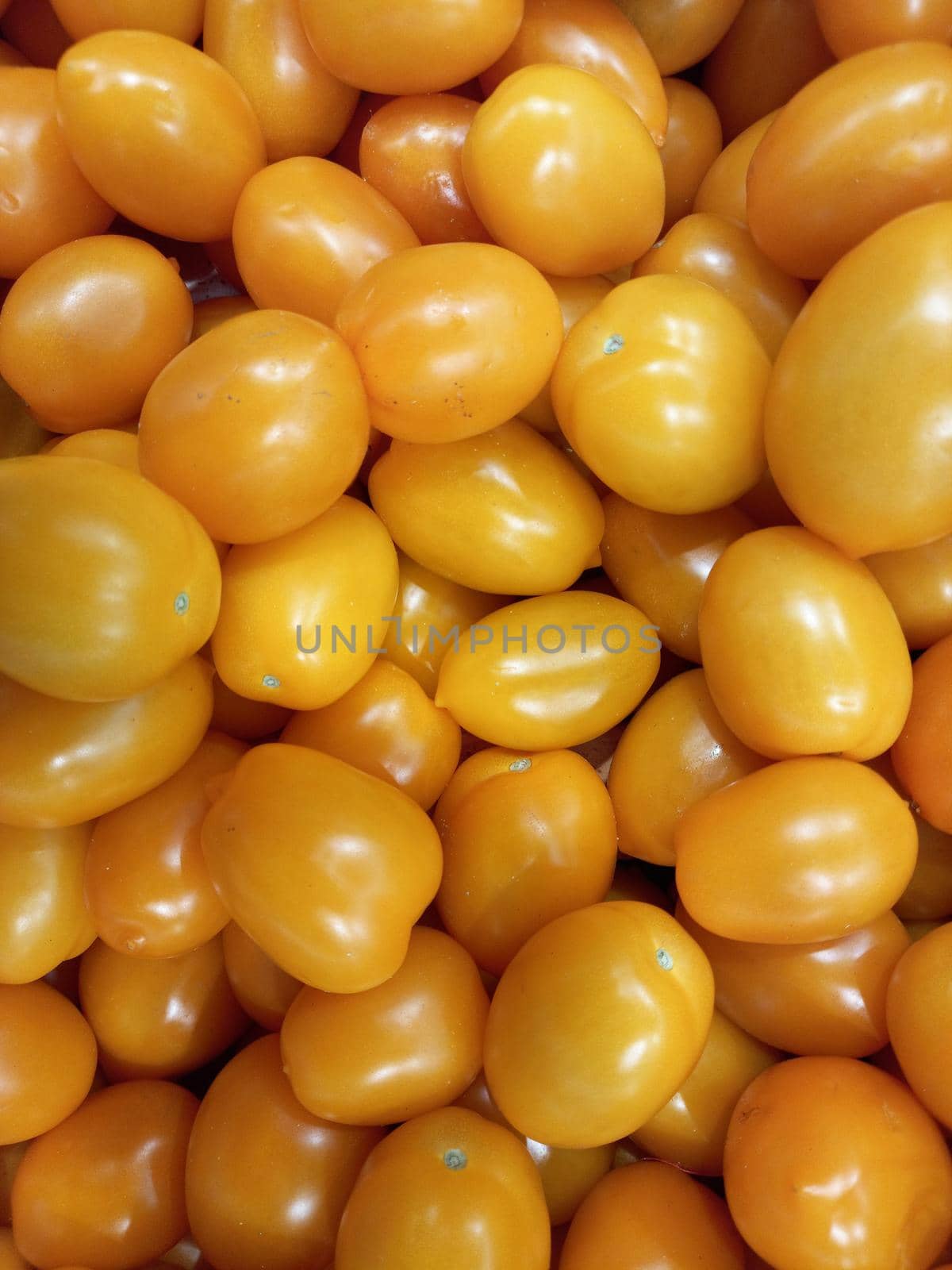 Ripe tomatoes. Yellow plum tomatoes in a box on the market. High quality photo