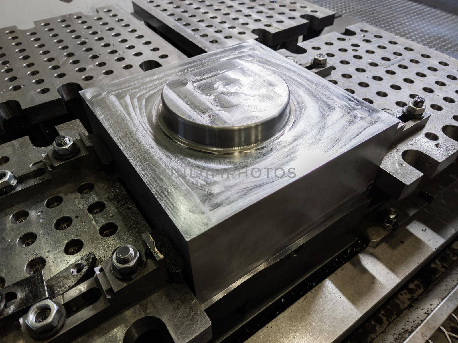 large steel workpiece after cnc surface milling on table of milling machine, industrial cnc technology backdrop.