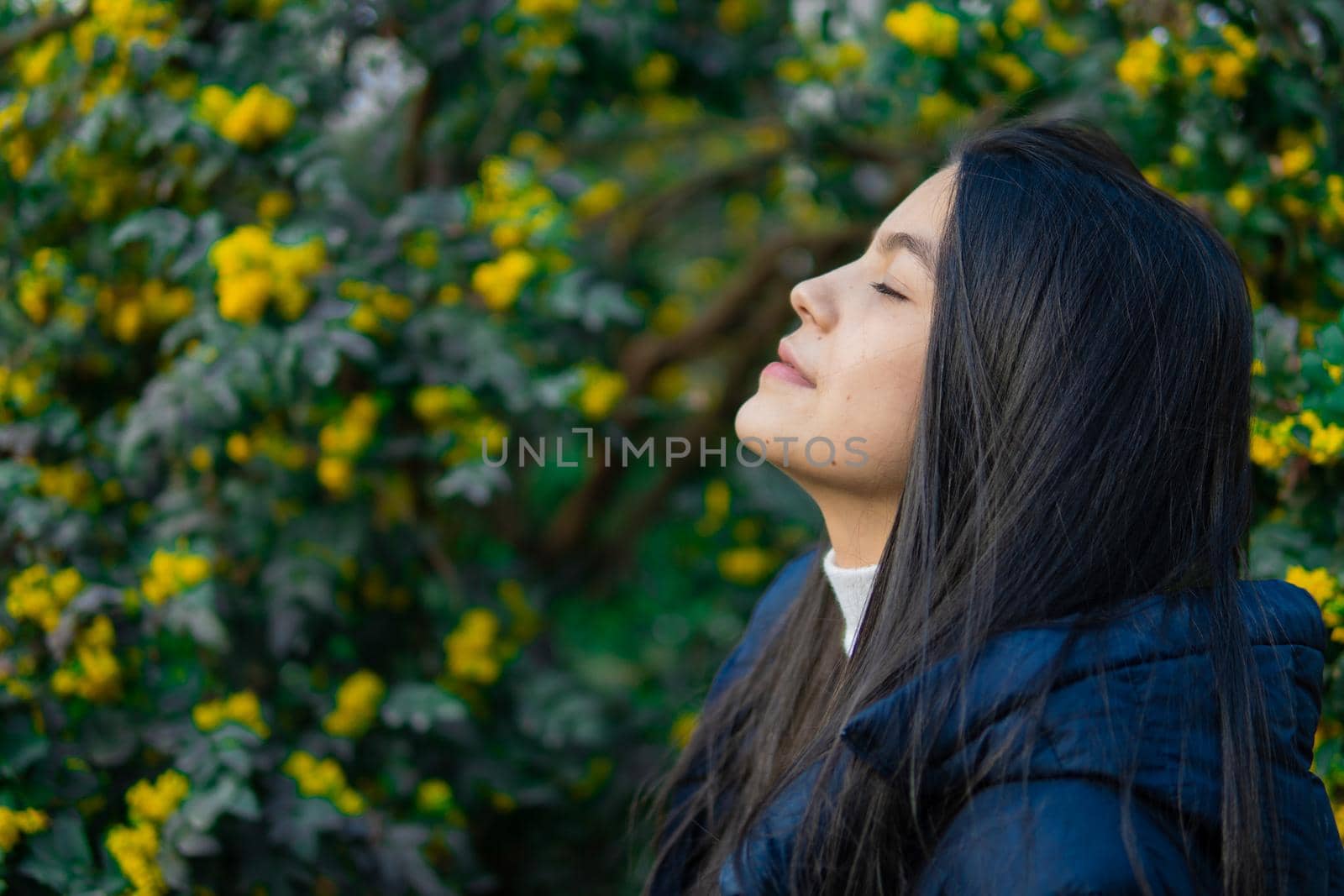 Portrait of young Colombian girl with yellow flowers in the background by xavier_photo