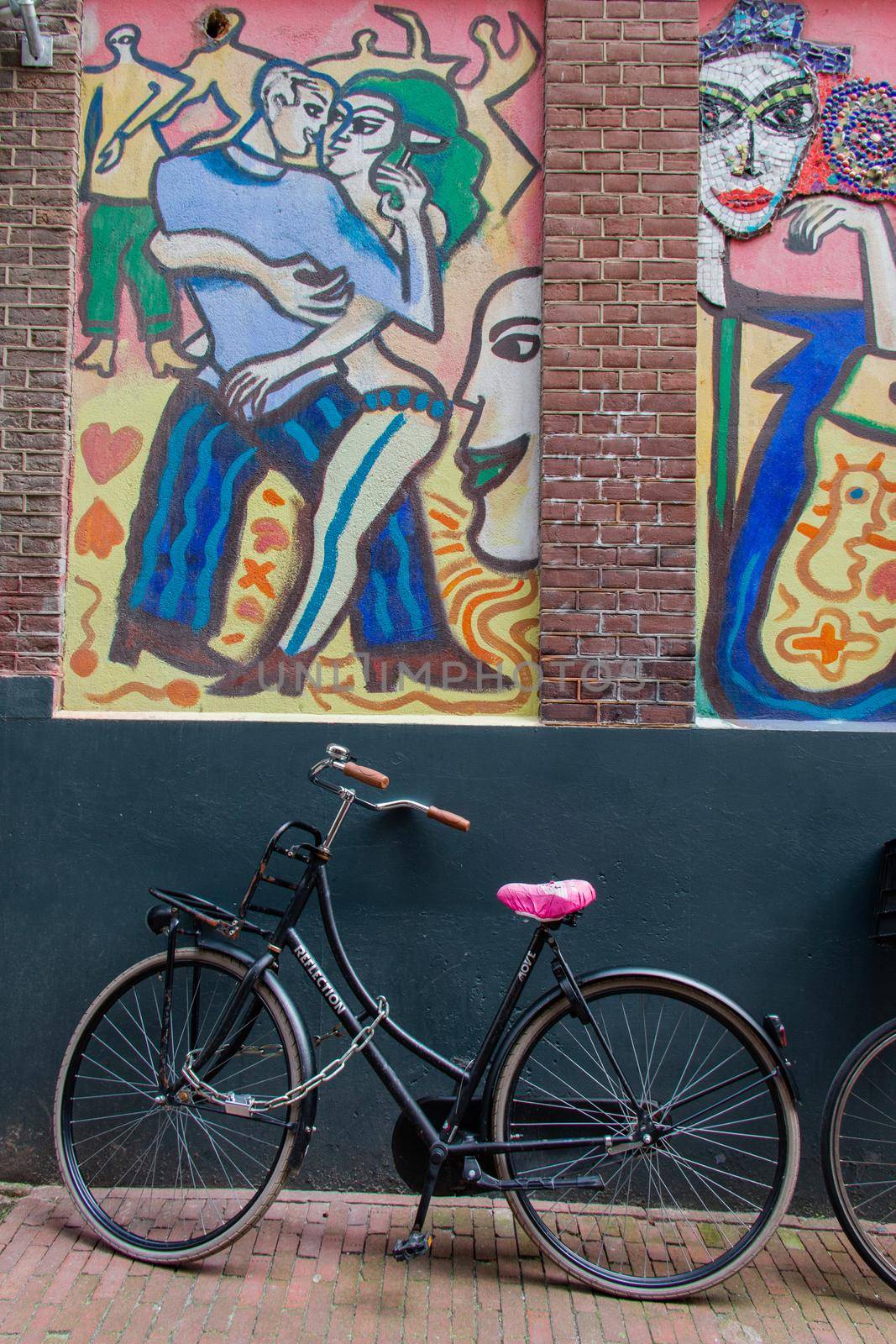 Bicycle parked under a modern painting of man and woman dancing by Kanelbulle