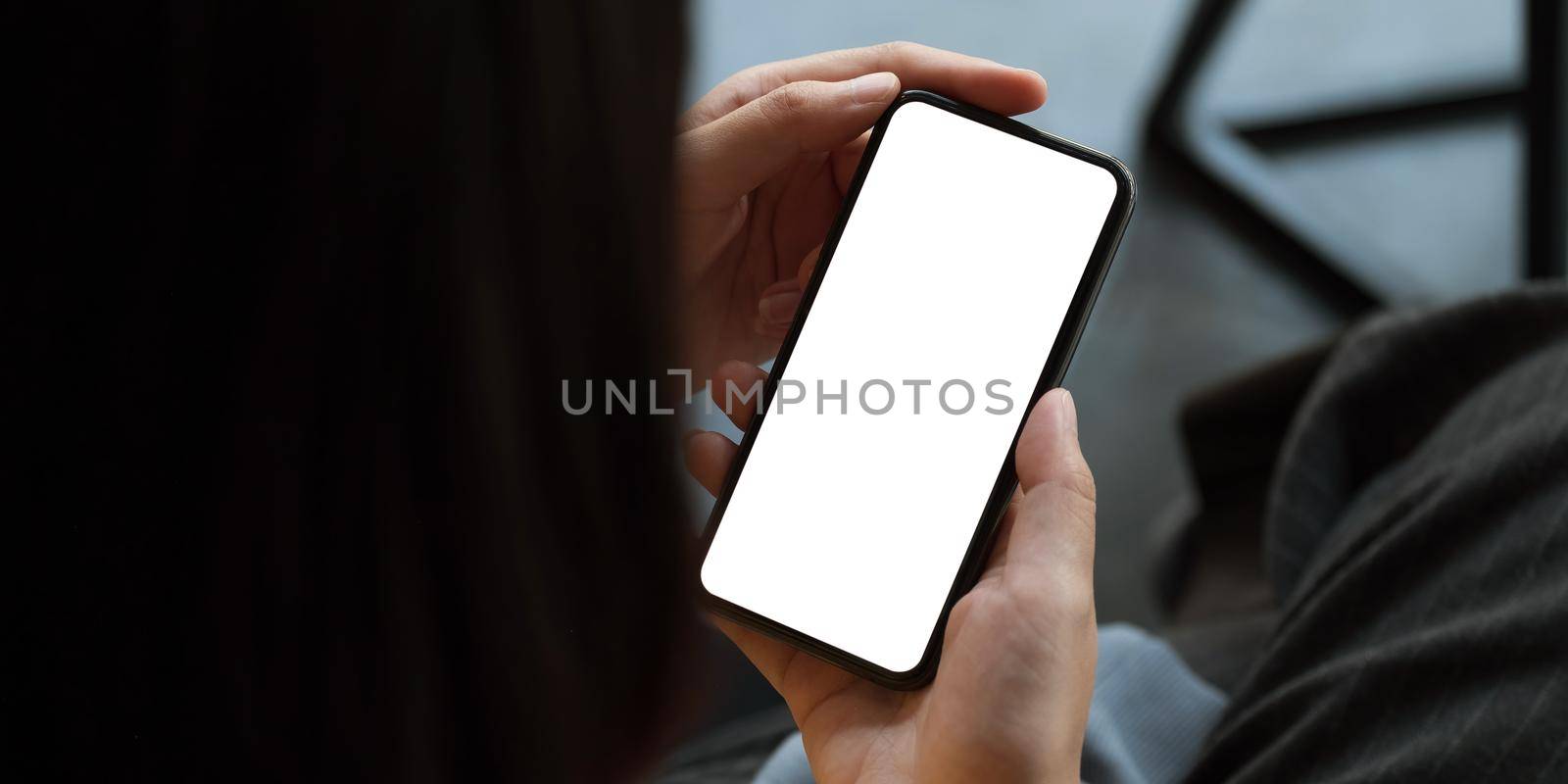 Top view Woman sitting and holding blank screen mock up mobile phone.. by nateemee