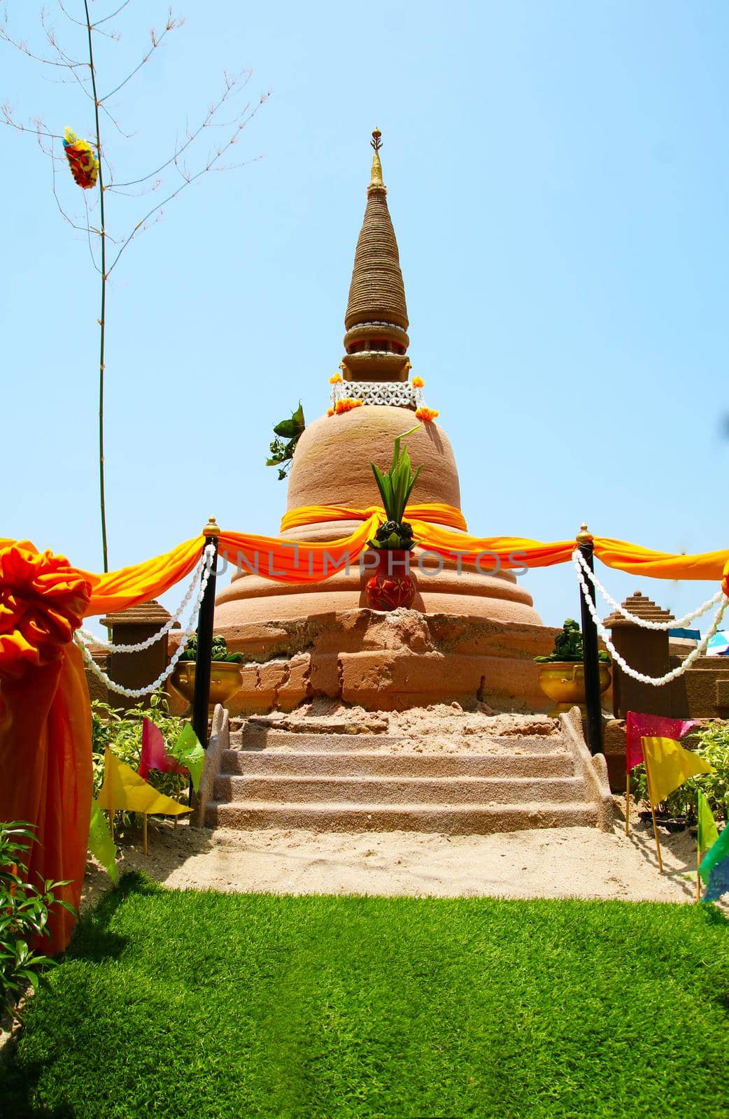 sand pagoda on green grass in Songkran festival represents In order to take the sand scraps attached to the feet from the temple to return the temple in the shape of a sand pagoda