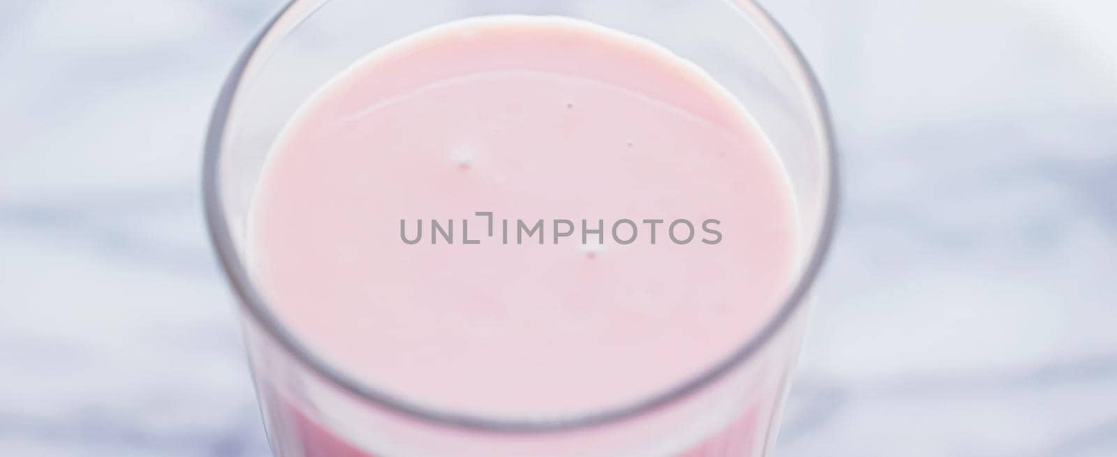 Strawberry milk on marble background as sweet drink, food service and meal delivery concept