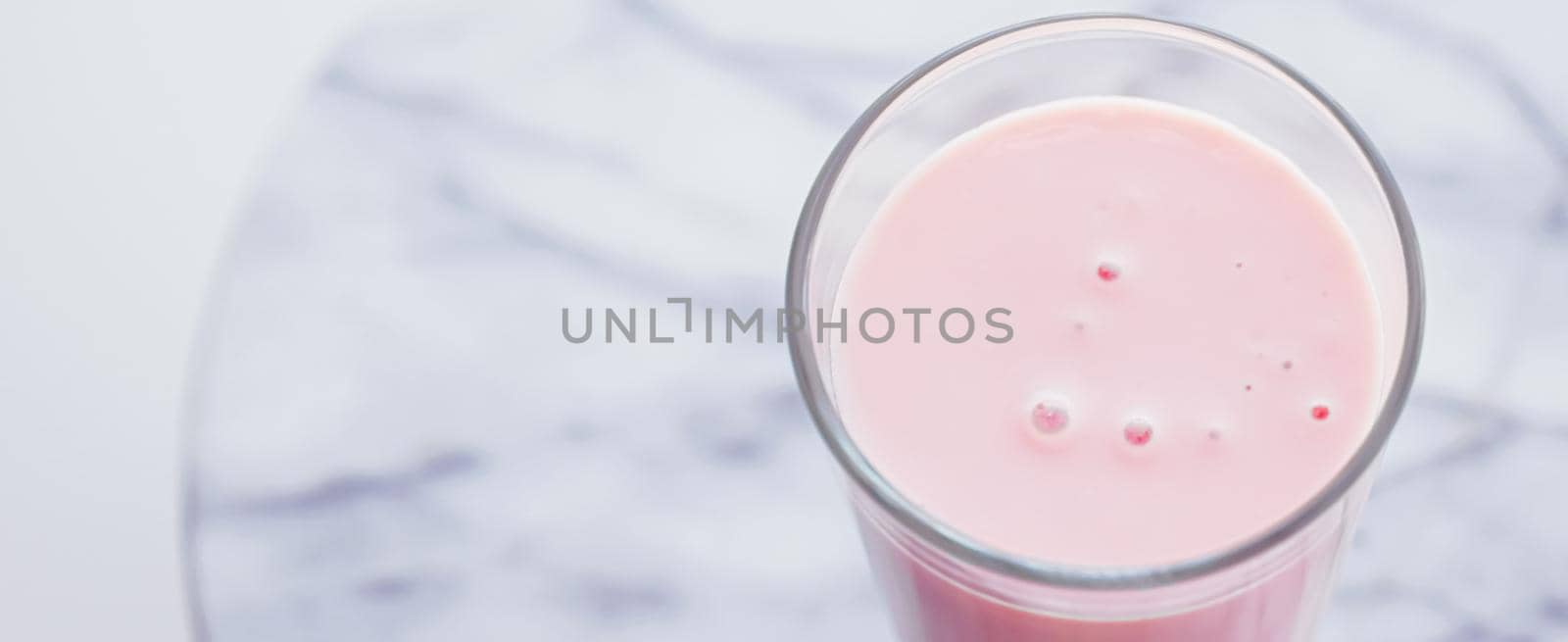 Strawberry milk on marble background as sweet drink, food service and meal delivery by Anneleven