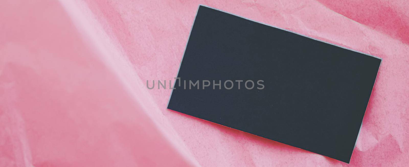 Black business card flatlay on pink tissue paper background, luxury branding flat lay and brand identity design for mockups