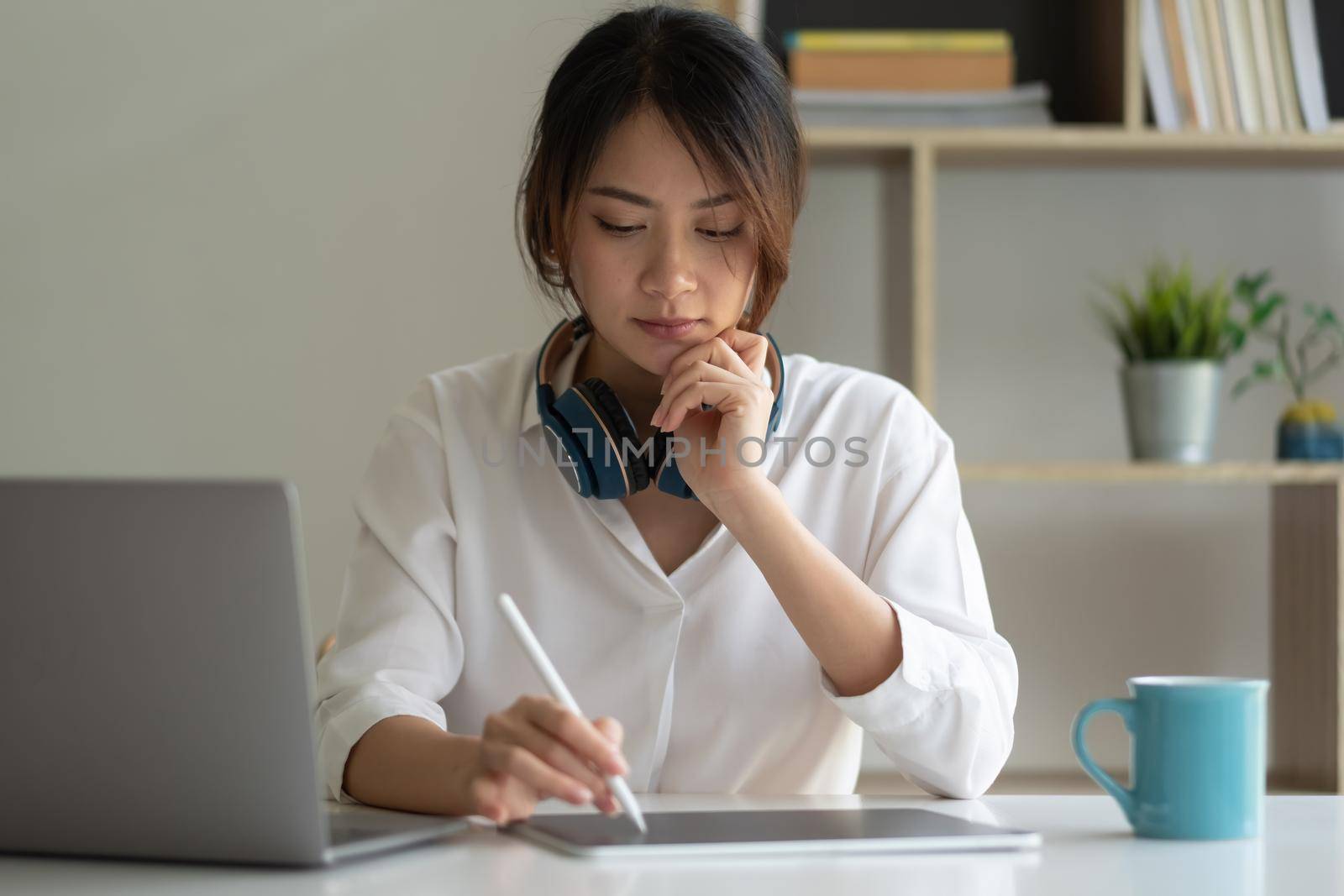 Shot of asian woman working with a stylus pen on a digital tablet and laptop computer at home. online study education