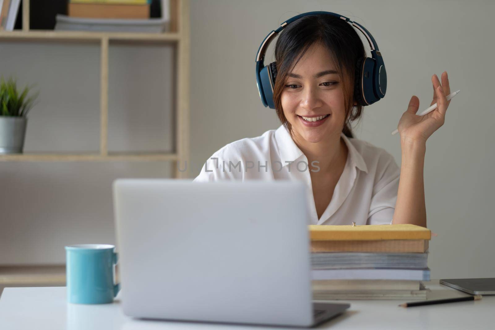 Asian woman wearing headphones study online watching webinar podcast on laptop listening learning education course conference calling, elearning concept.