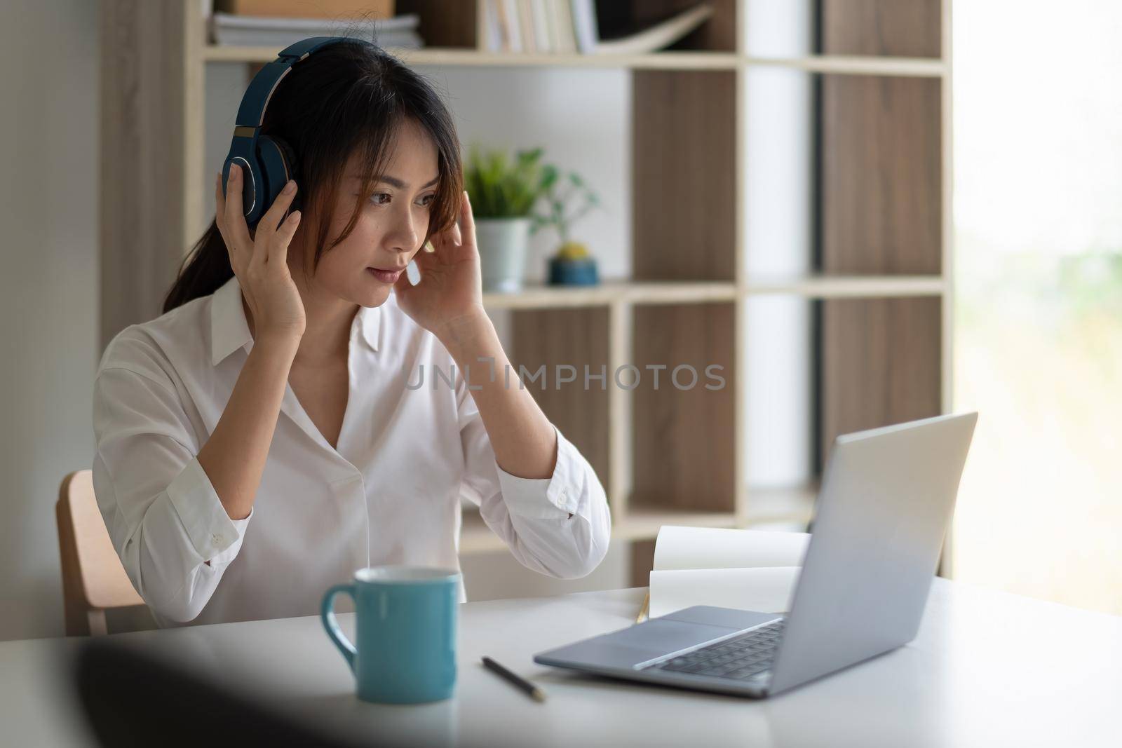 Beautiful asian woman in headphones have video call distant class with teacher using laptop - Online learning concept. by nateemee