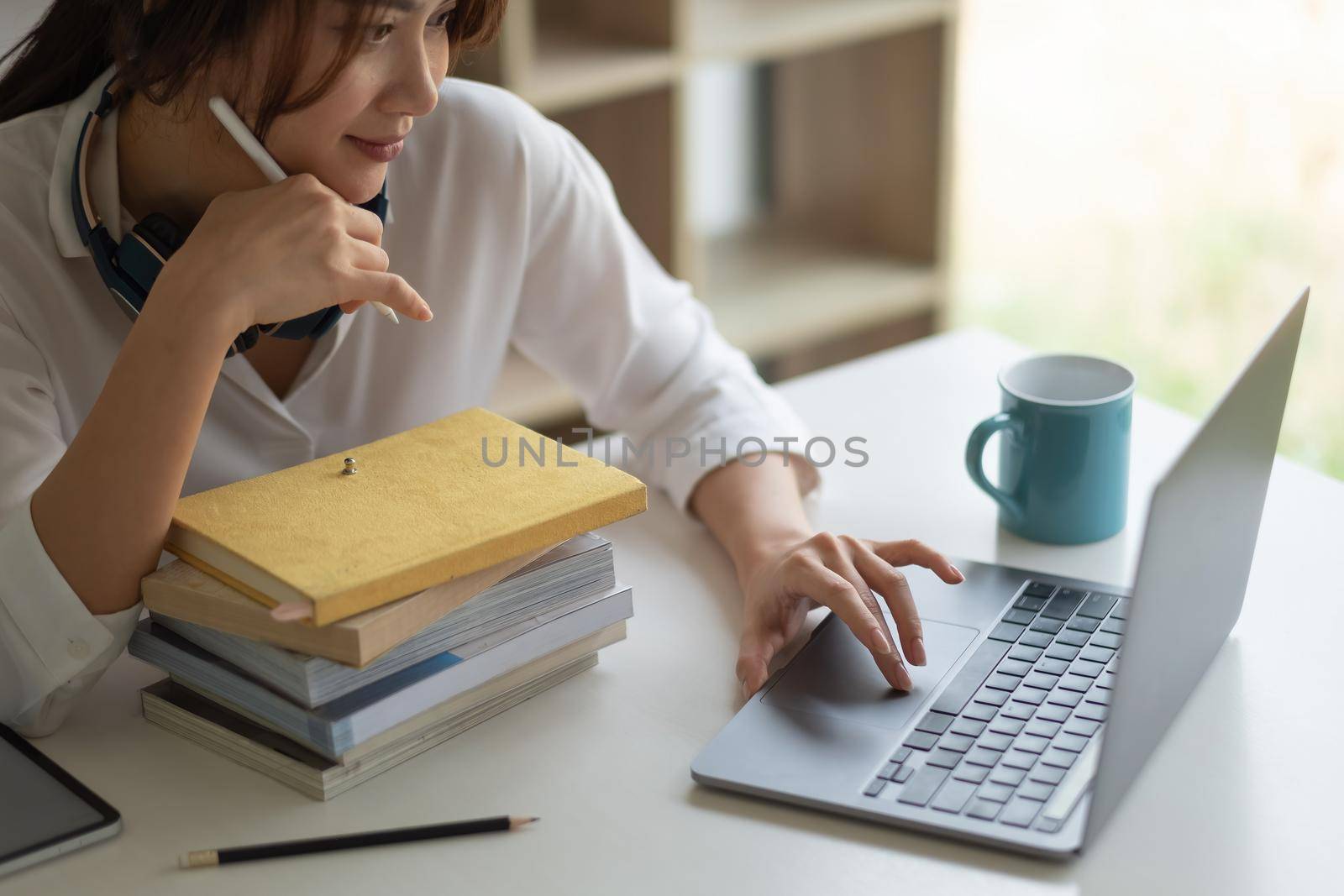 Asian woman with headphones study online watching webinar podcast on laptop listening learning education course conference calling, elearning concept